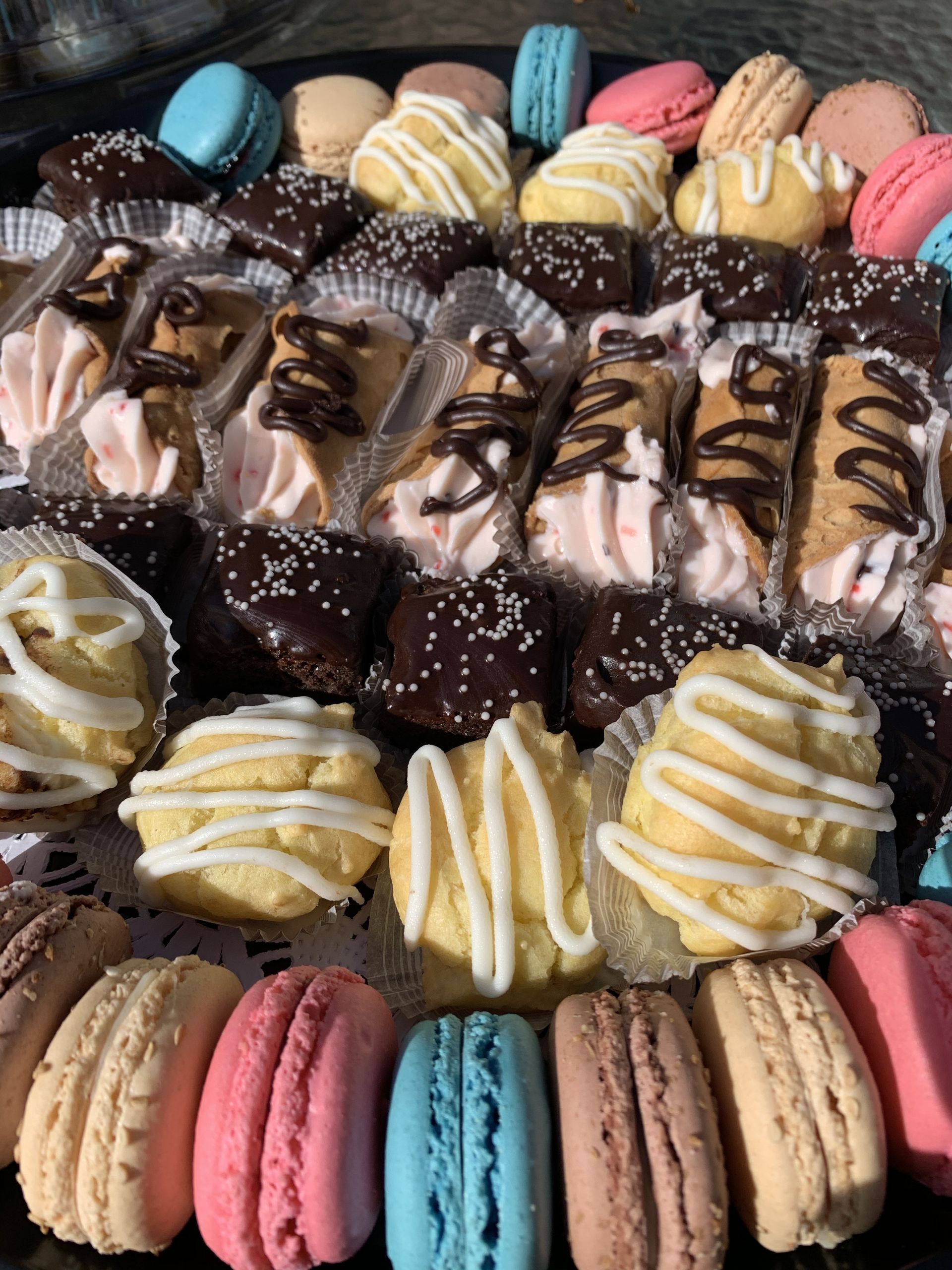 a tray of different types of cookies and macarons on a table .