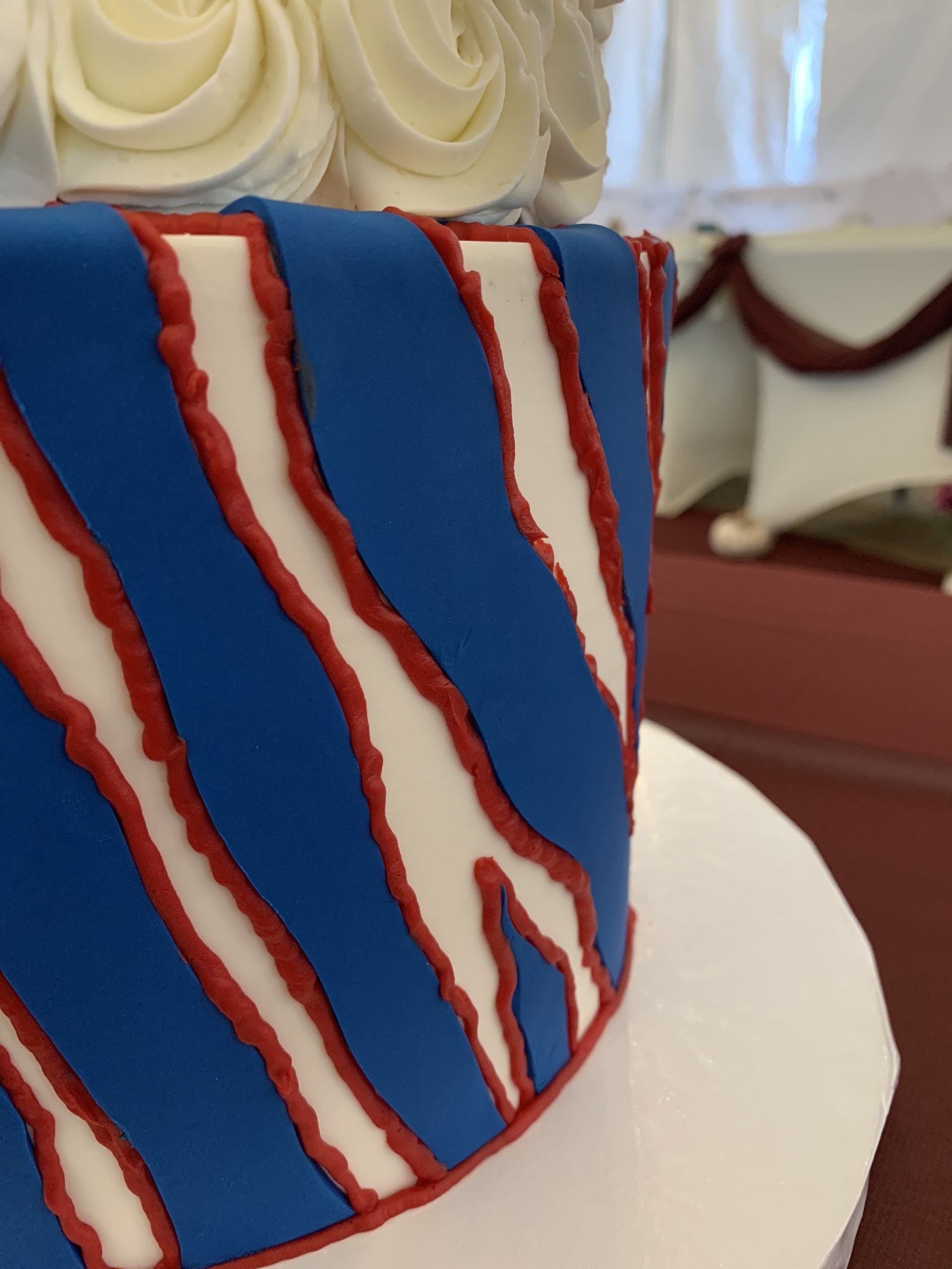 a blue and white cake with red stripes on it