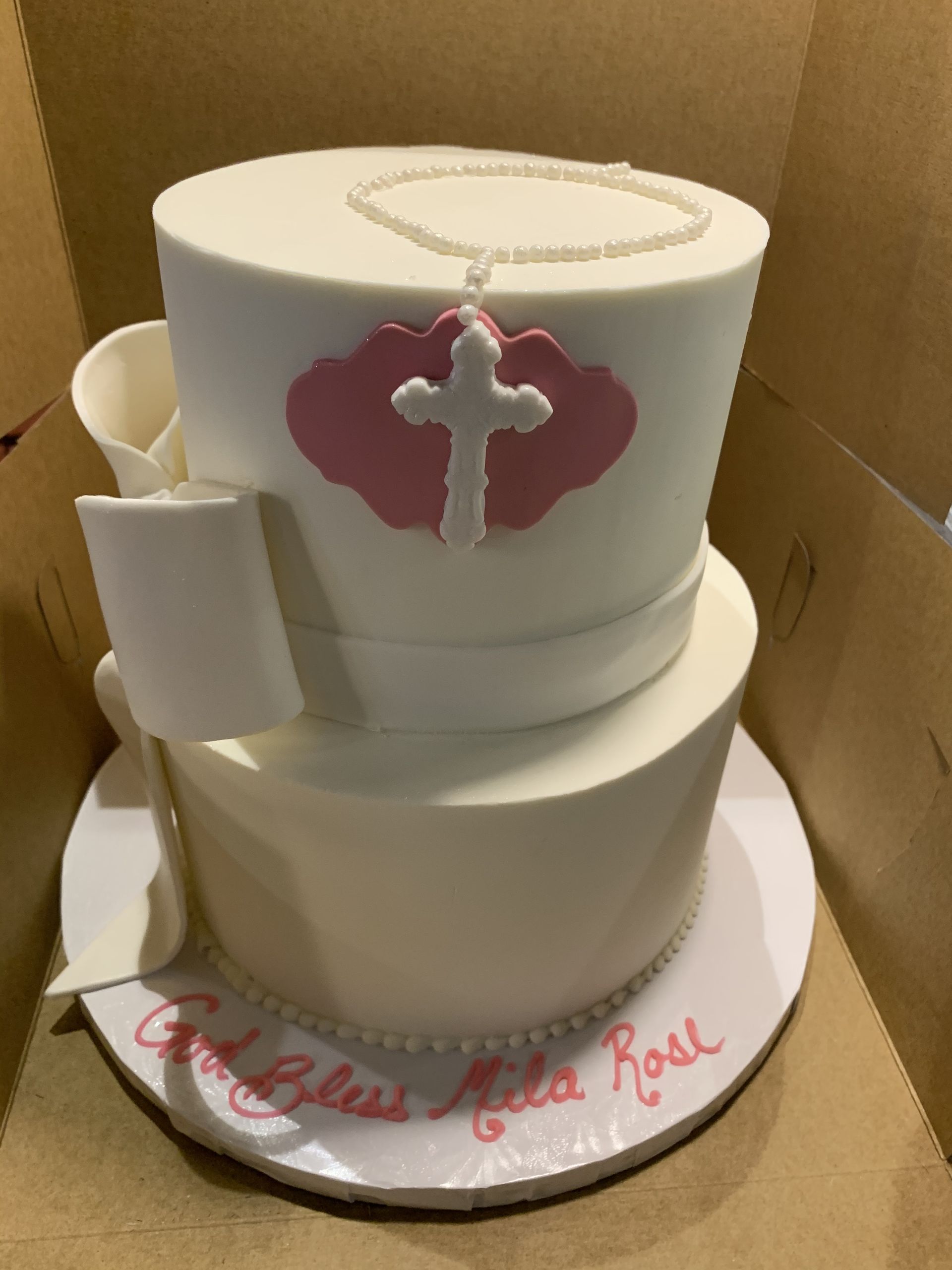 a white cake with a cross on it is in a box