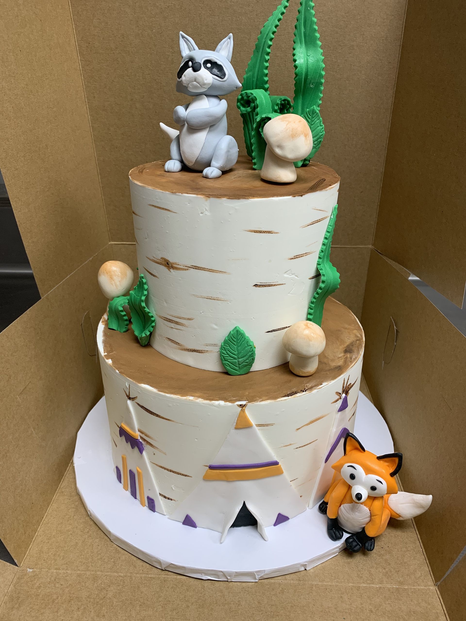 a cake with a raccoon and a fox on top of it