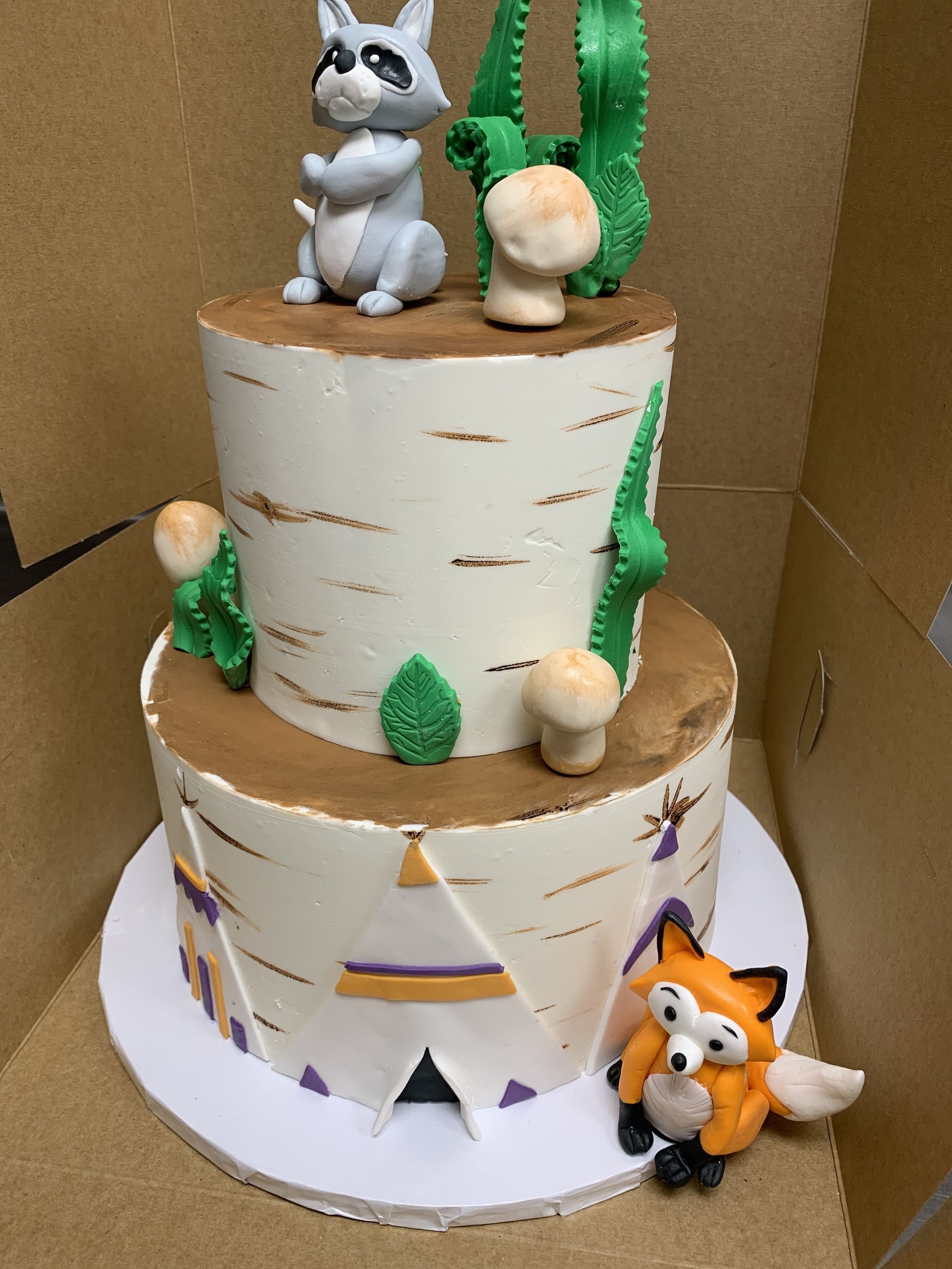 a cake with a raccoon and a fox on top of it
