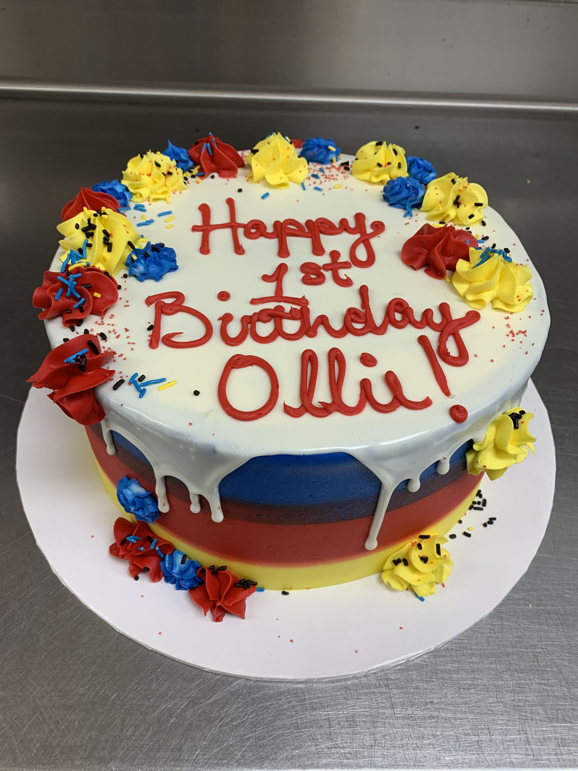 a birthday cake that says happy 1st birthday ollie