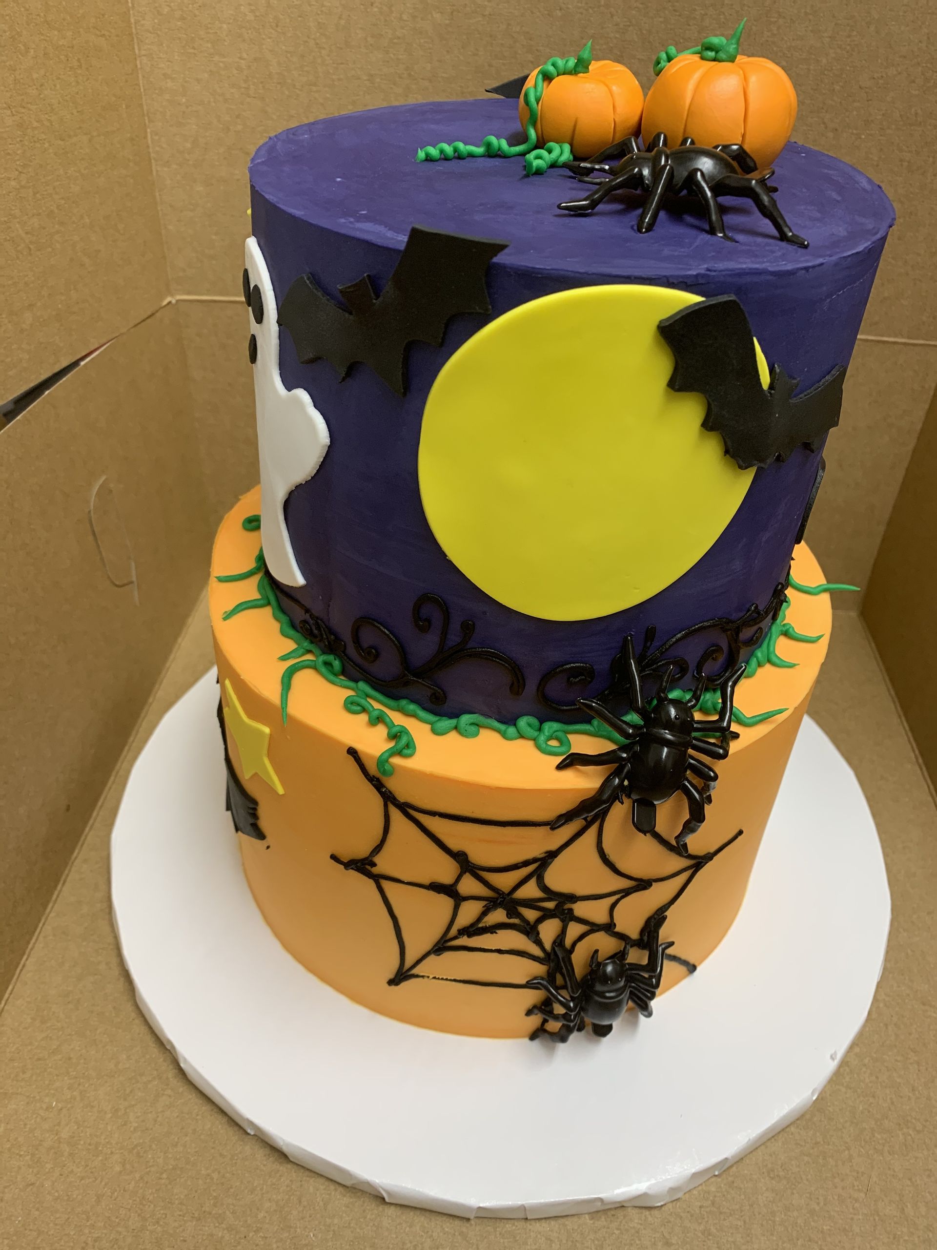 a halloween cake with bats pumpkins and spiders on it
