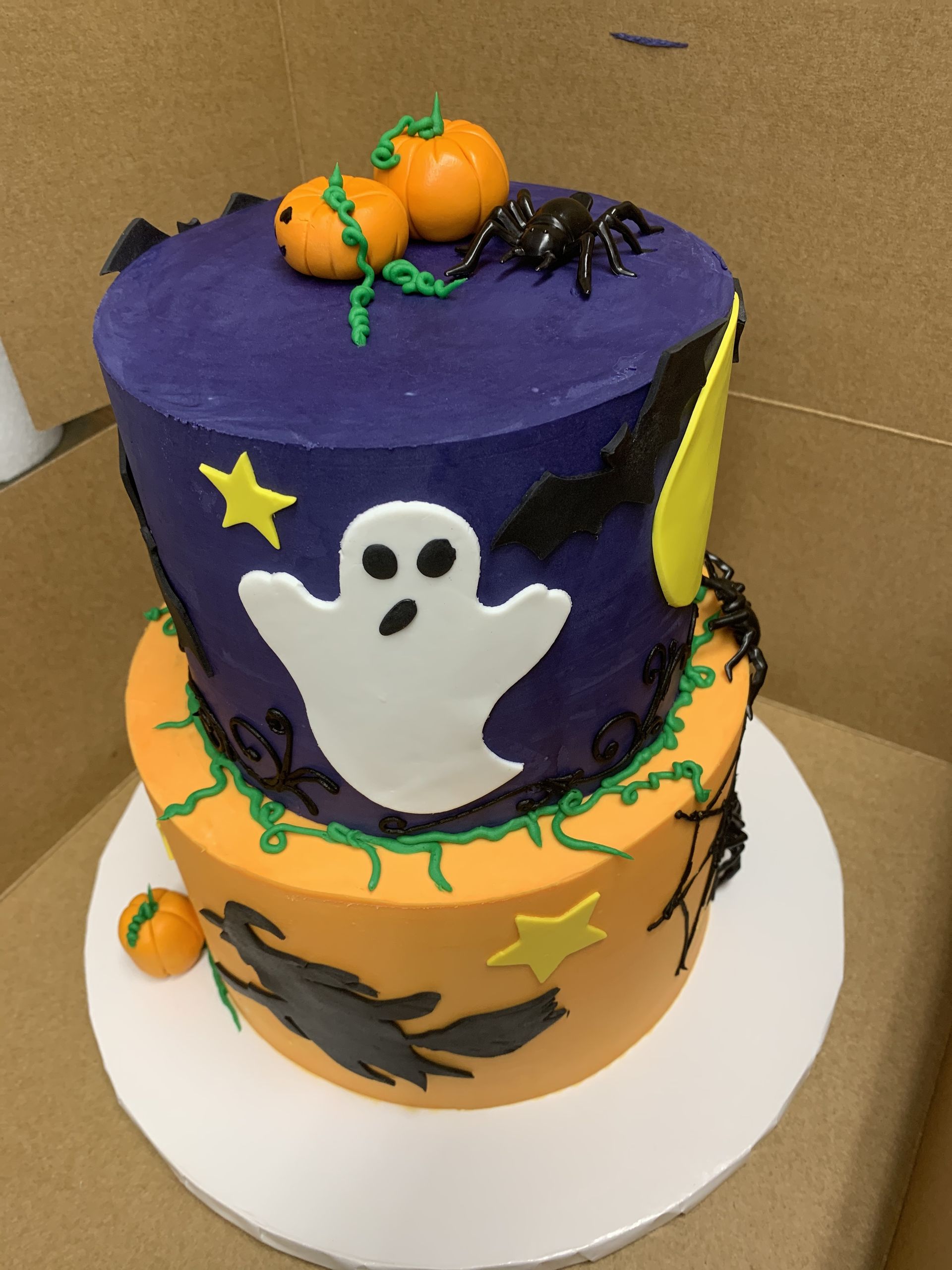 a halloween cake with a ghost and pumpkins on top