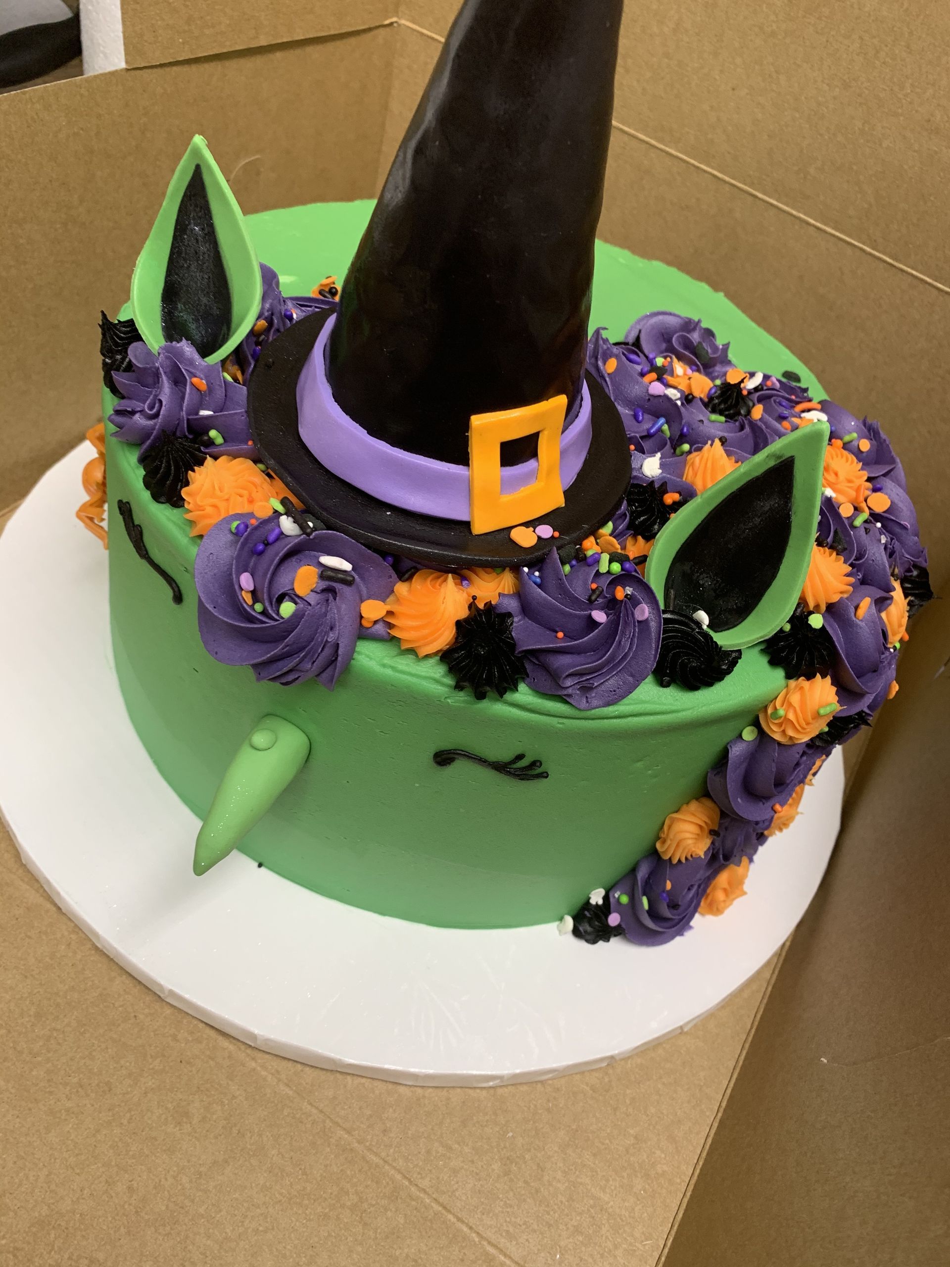 a green cake with a witch hat on top of it