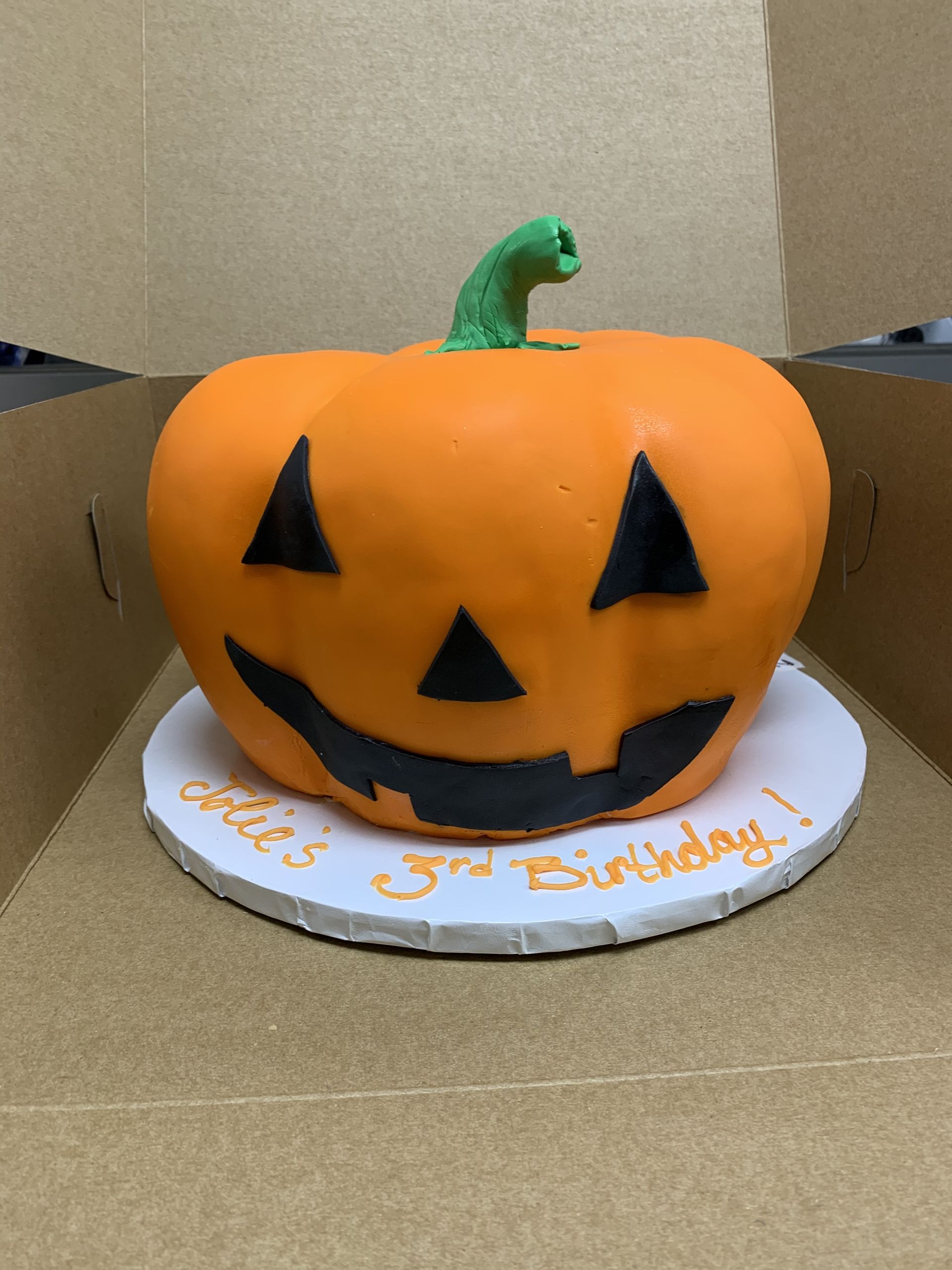 a cake in the shape of a pumpkin for a 3rd birthday