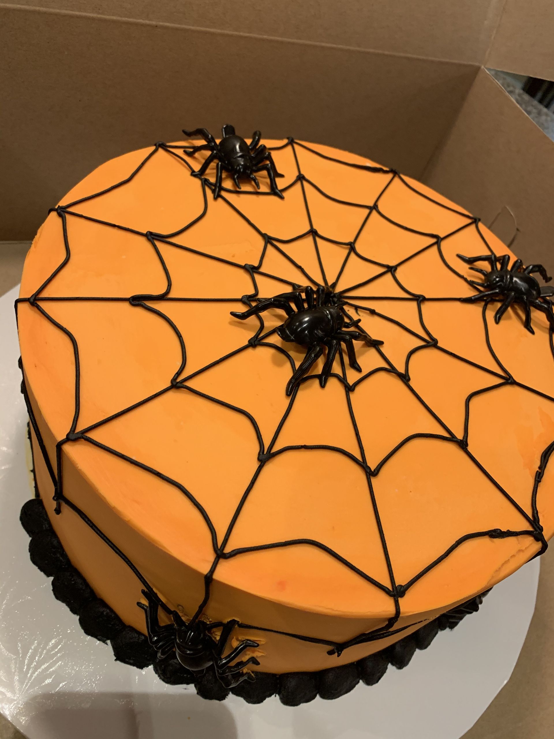a halloween cake with spider webs and spiders on it