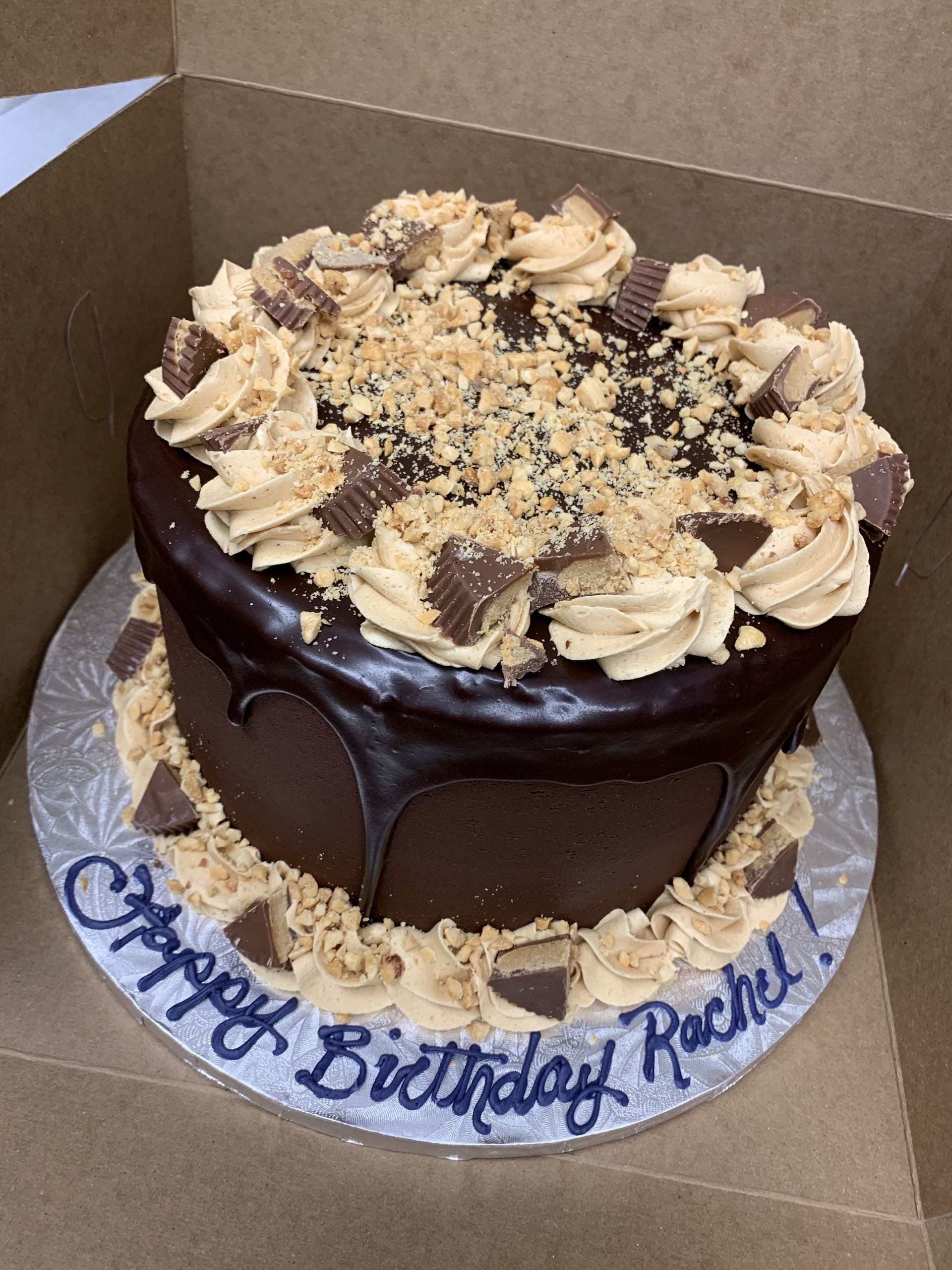 a chocolate cake with peanut butter frosting is in a box .