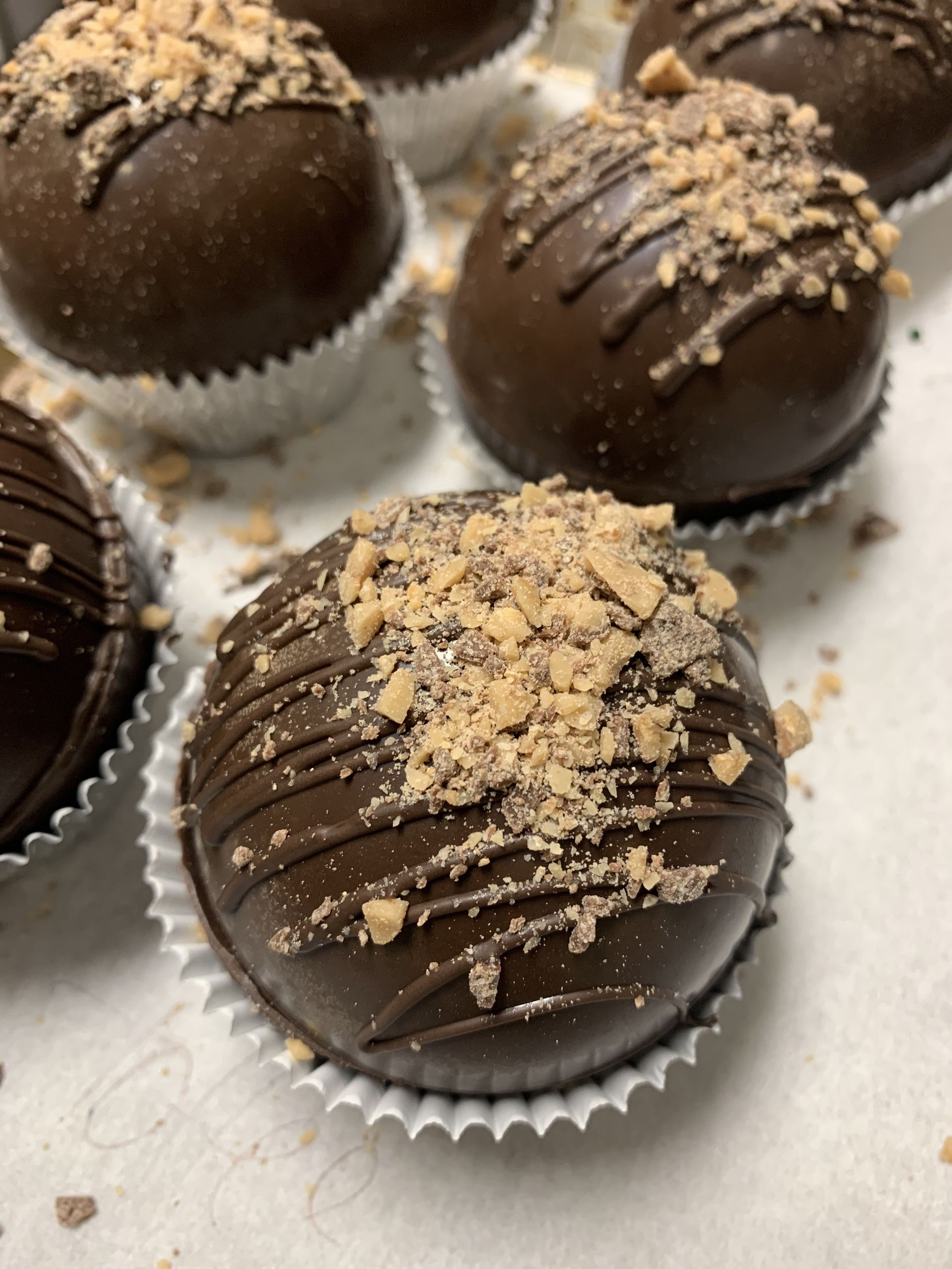 a group of chocolate covered cupcakes with nuts on top