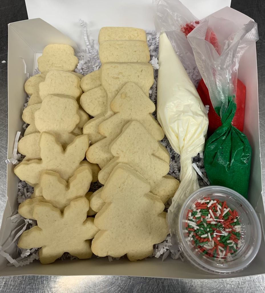 a box of christmas cookies with frosting and sprinkles