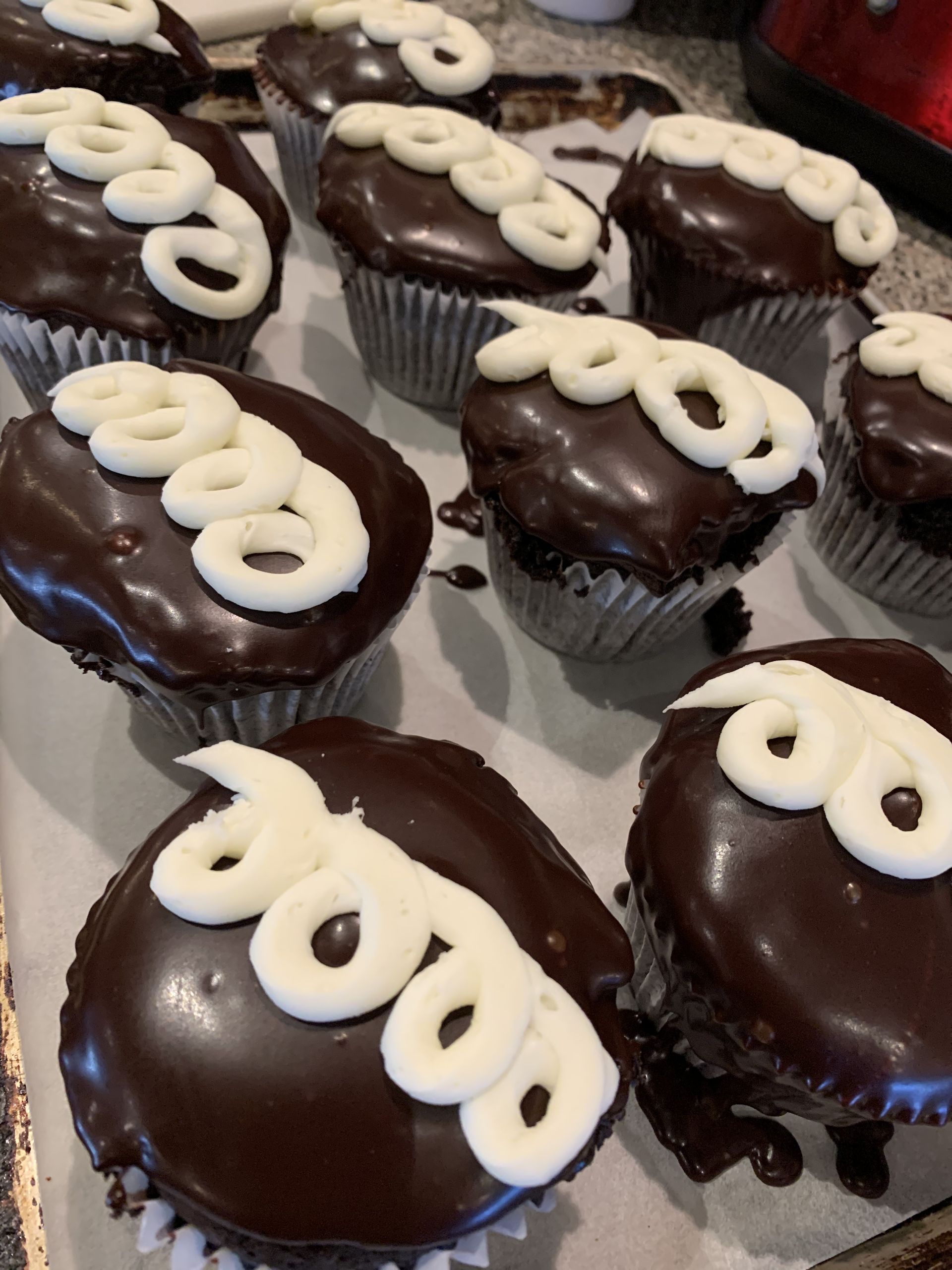 a bunch of chocolate cupcakes with white frosting on them