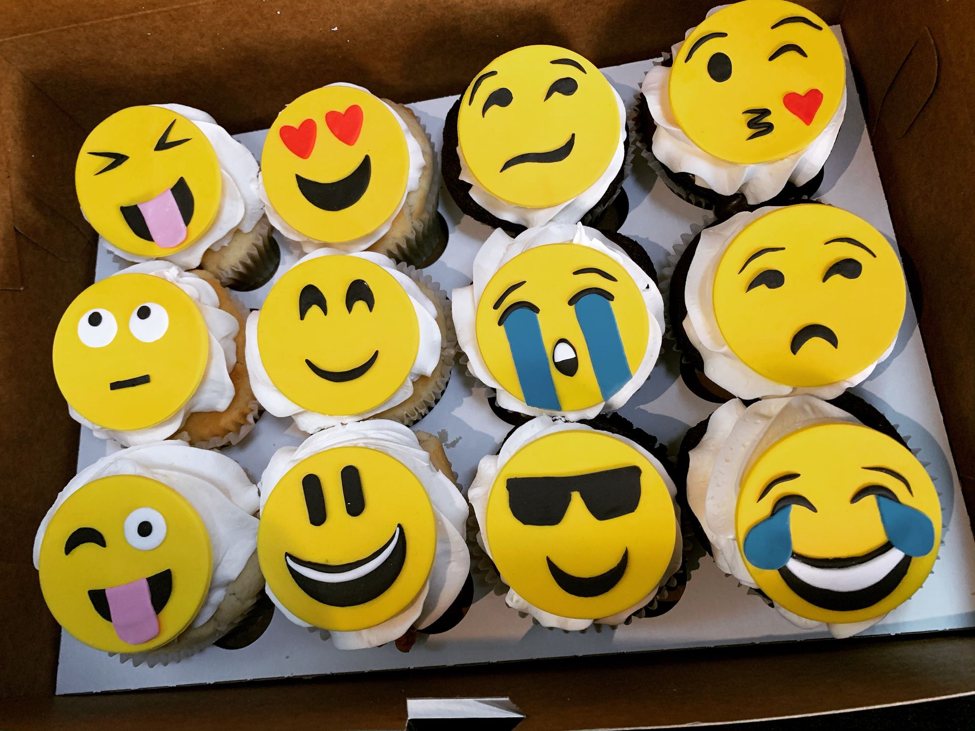 a box of cupcakes with smiley faces on them