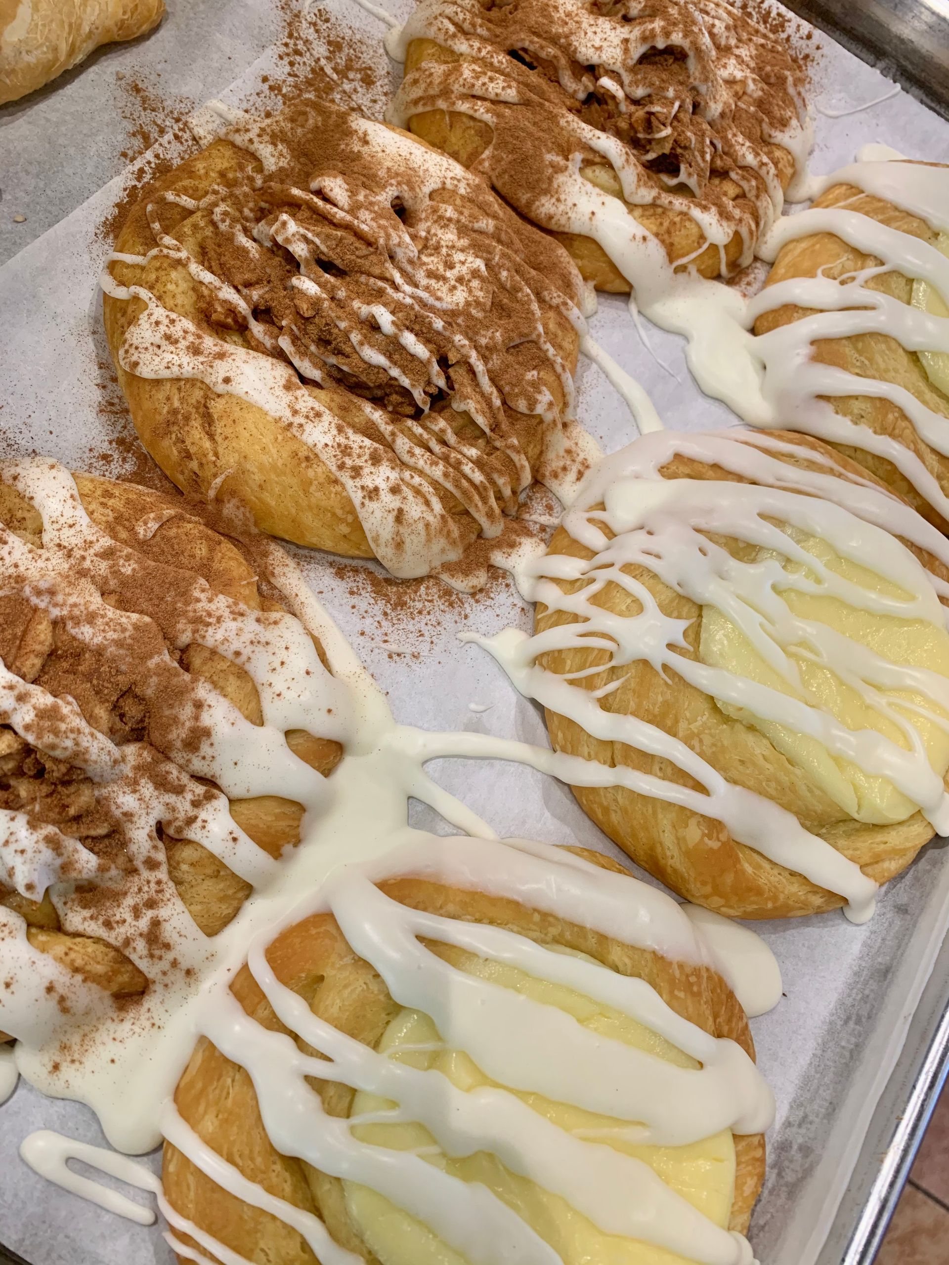 a bunch of pastries on a tray with icing on them