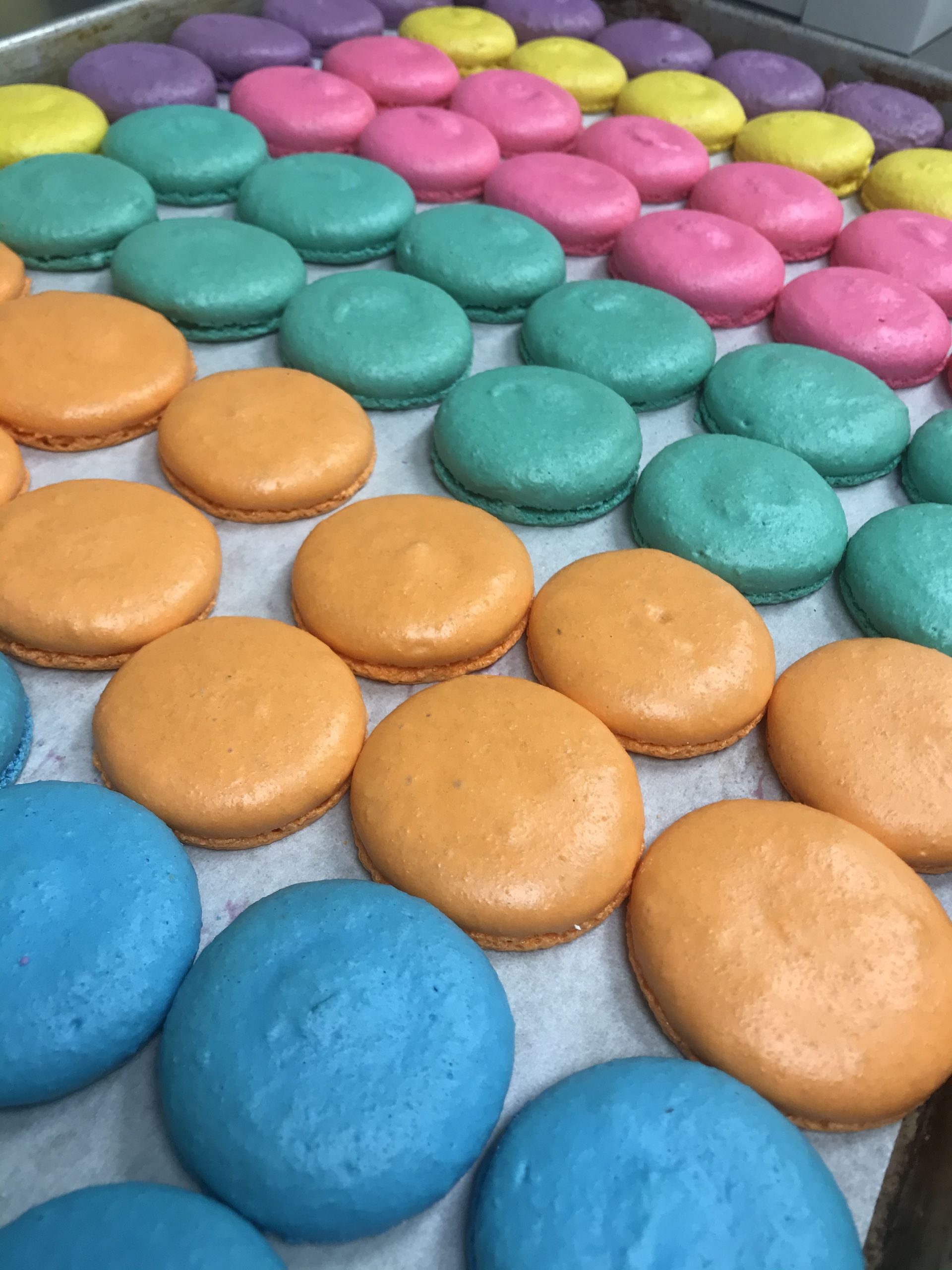 a bunch of different colored macarons on a tray