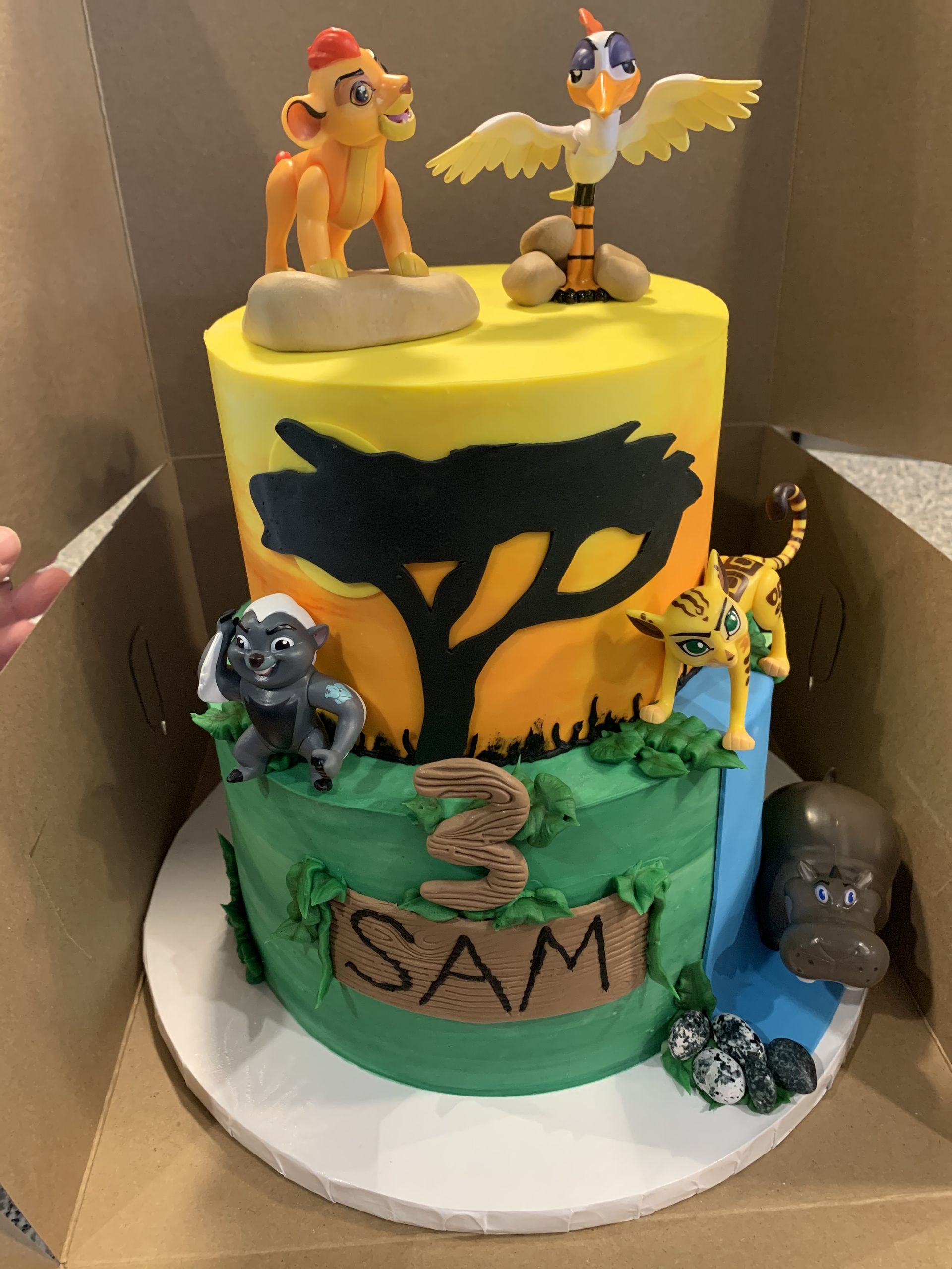a cake with a lion king theme is in a box .
