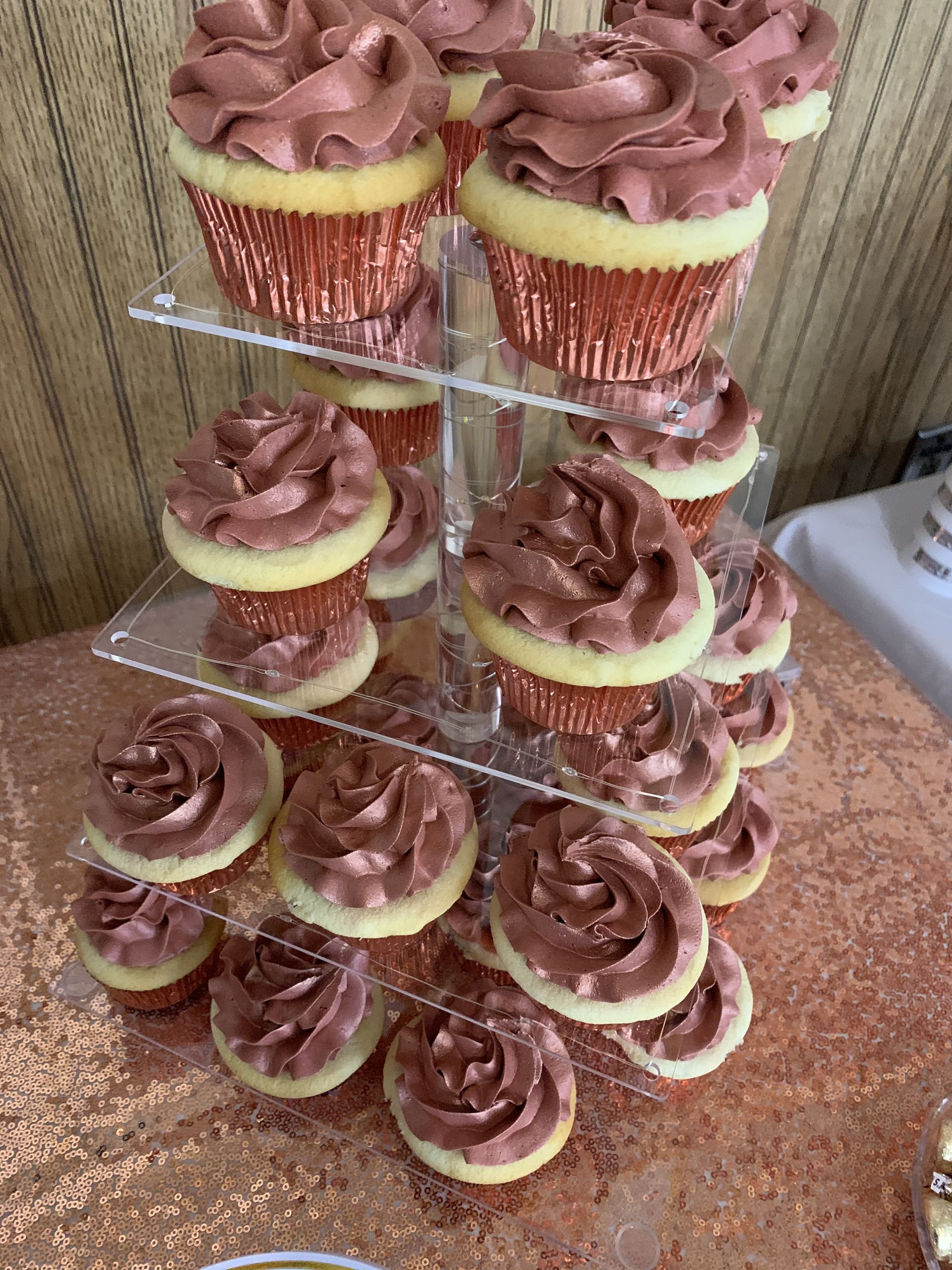 a cupcake tower filled with cupcakes on a table .