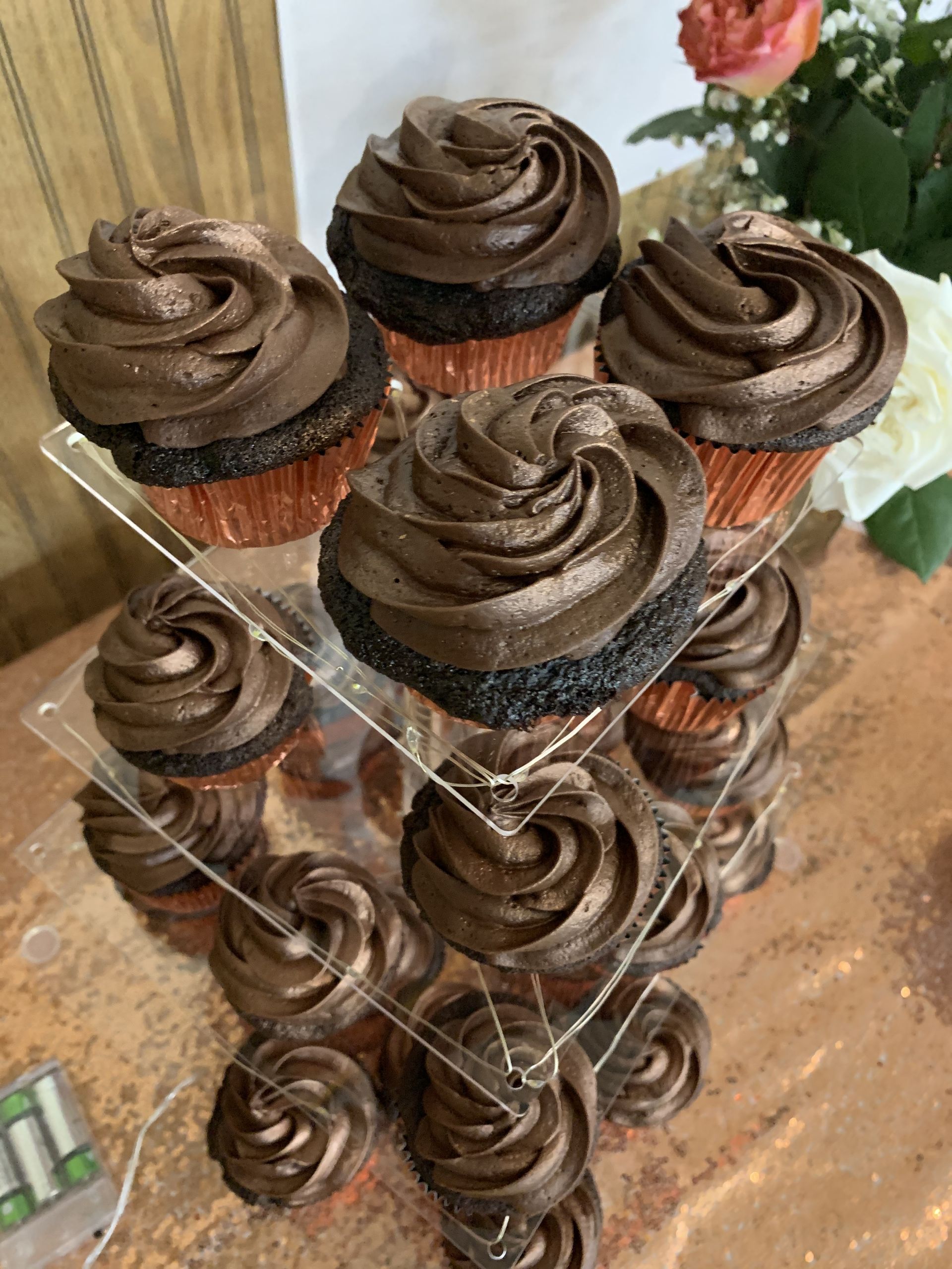 a stack of chocolate cupcakes with chocolate frosting on a table .