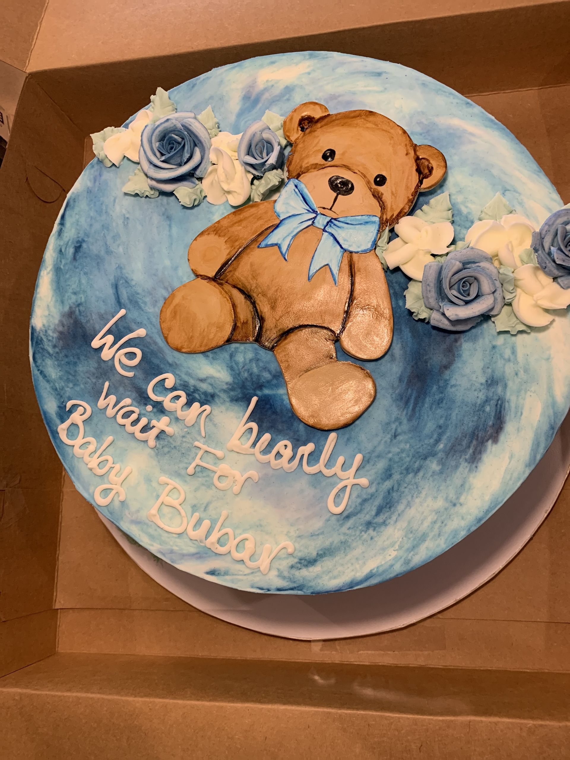 a baby shower cake with a teddy bear on it