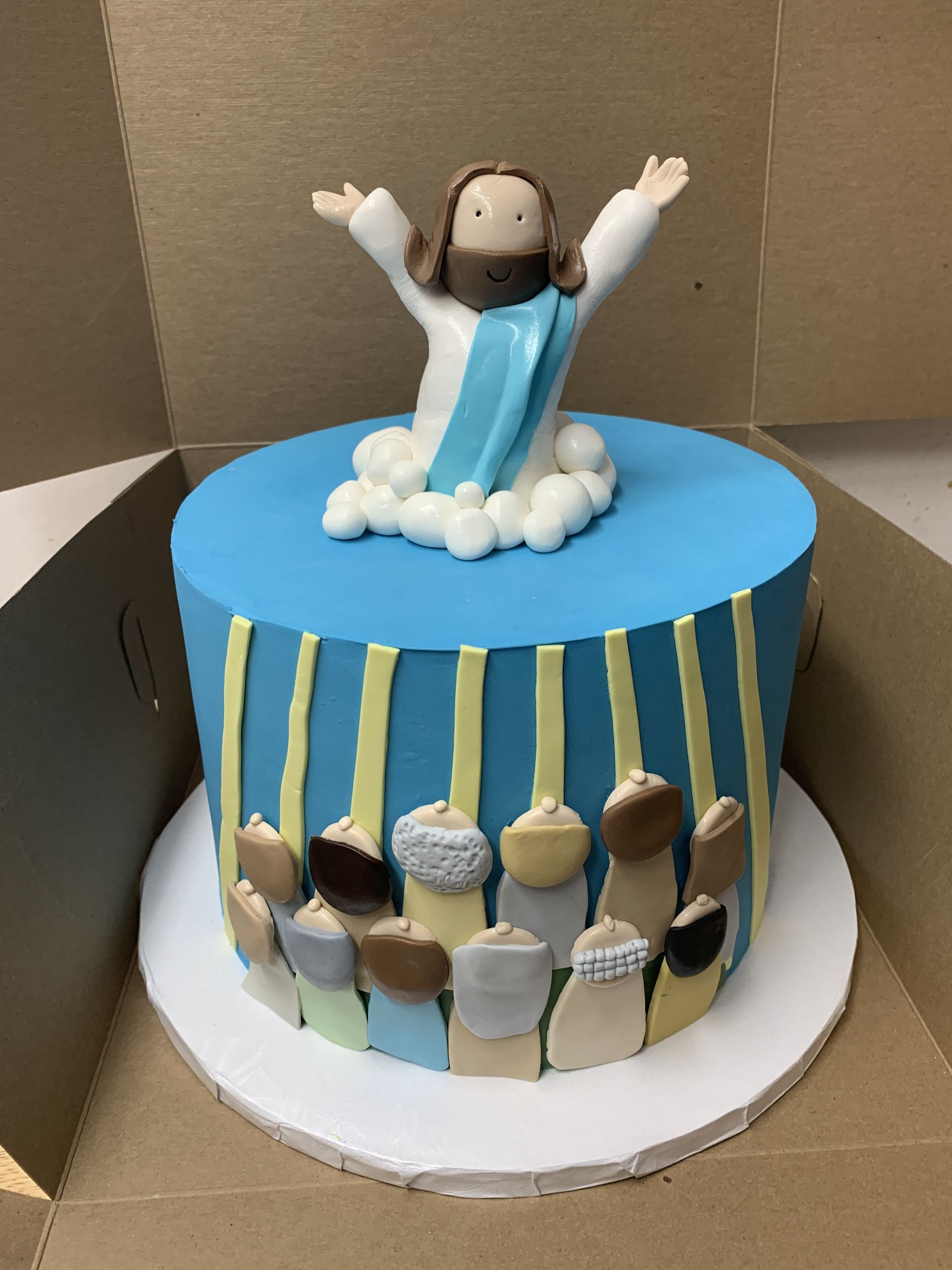 a cake with jesus on top of it in a box