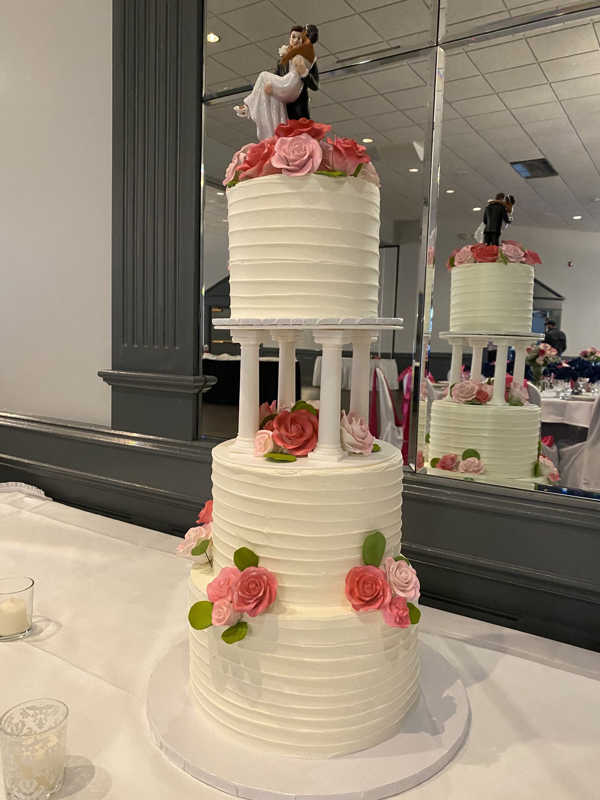 a wedding cake with a bride and groom figurine on top is sitting on a table .