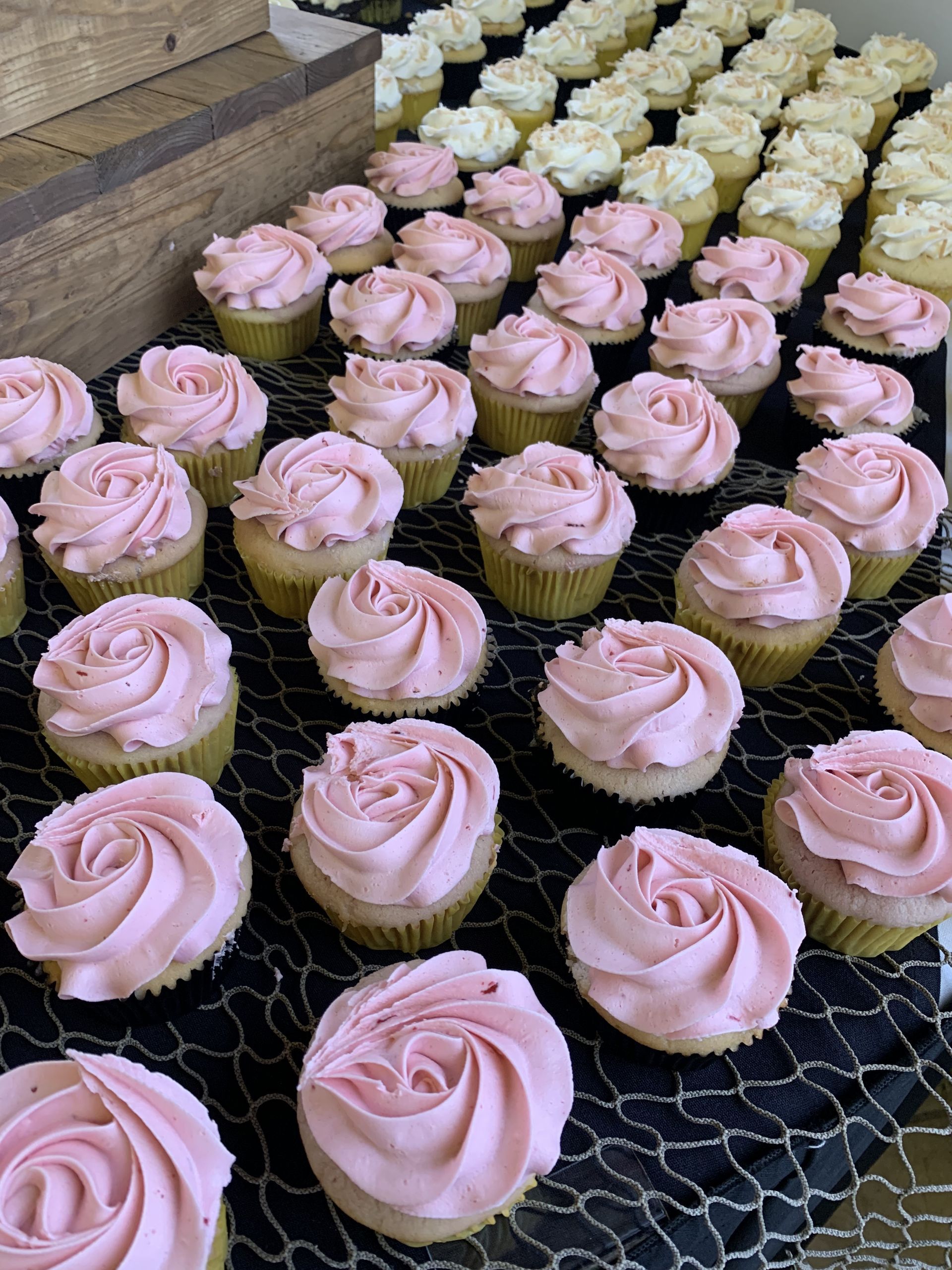 a bunch of cupcakes with pink frosting are sitting on a table .