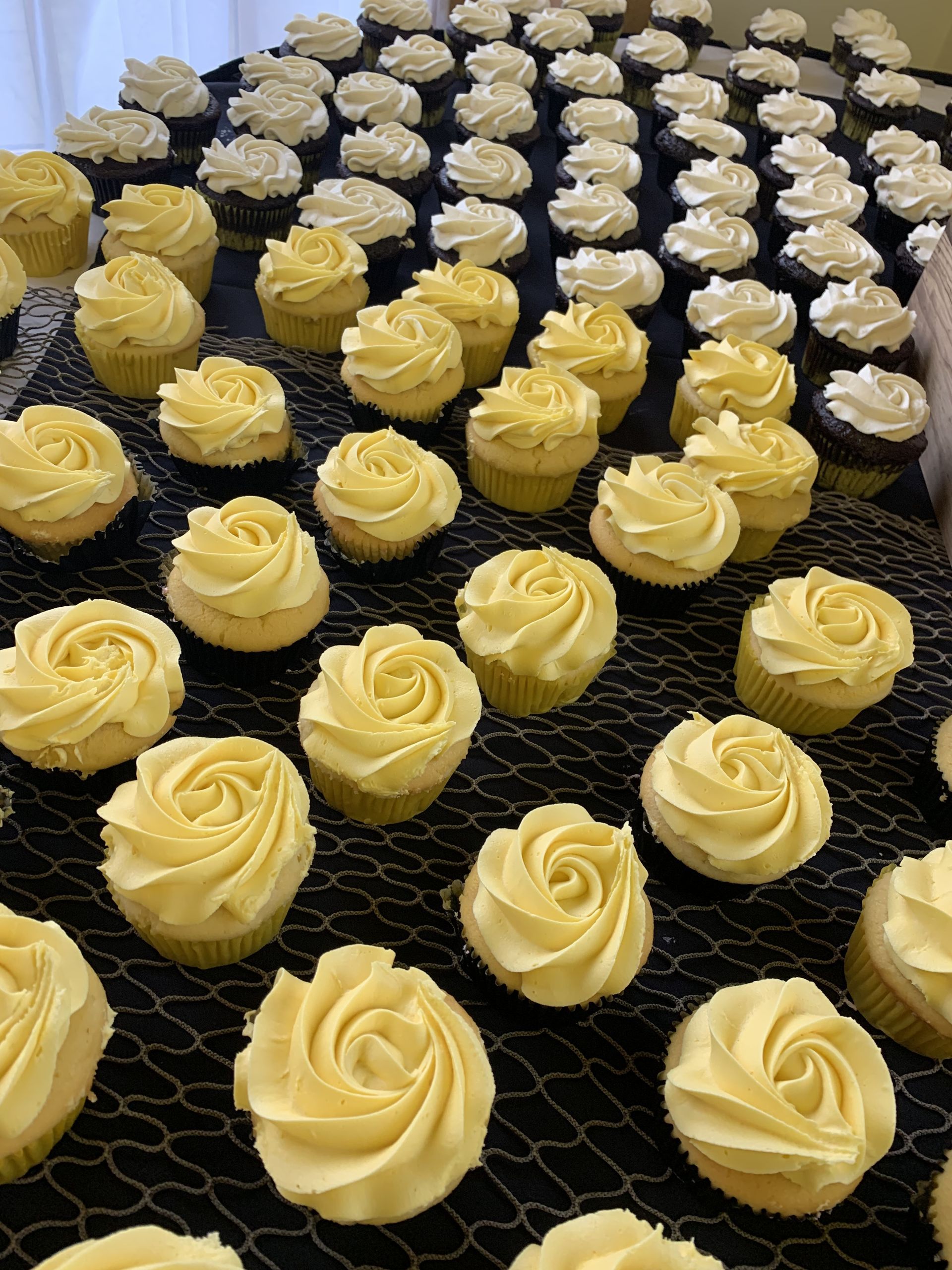 a bunch of cupcakes with yellow frosting are sitting on a table .