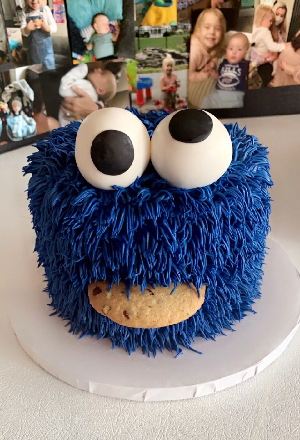 a cookie monster cake with a cookie in its mouth