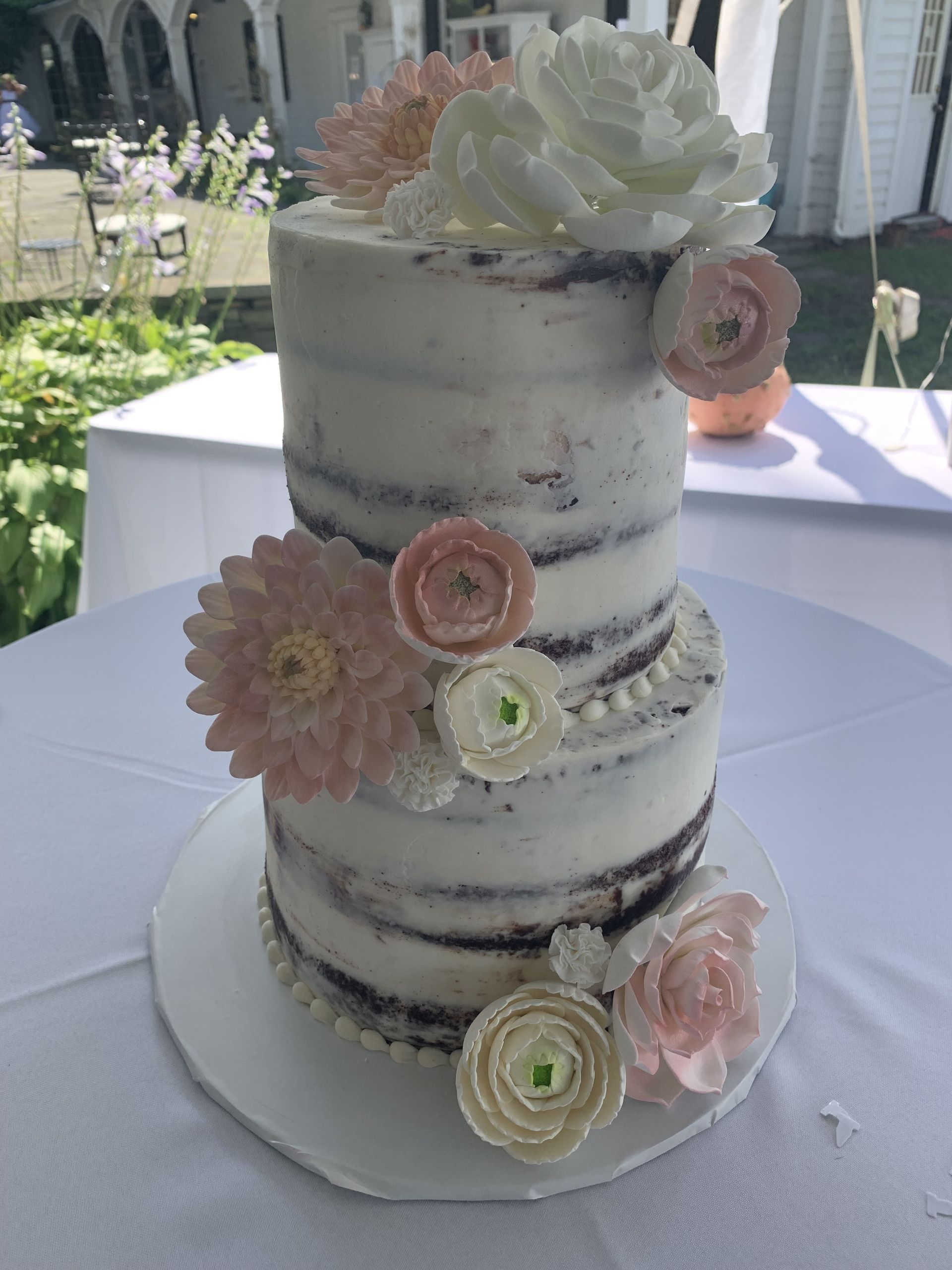 a cake with flowers on it is sitting on a table .