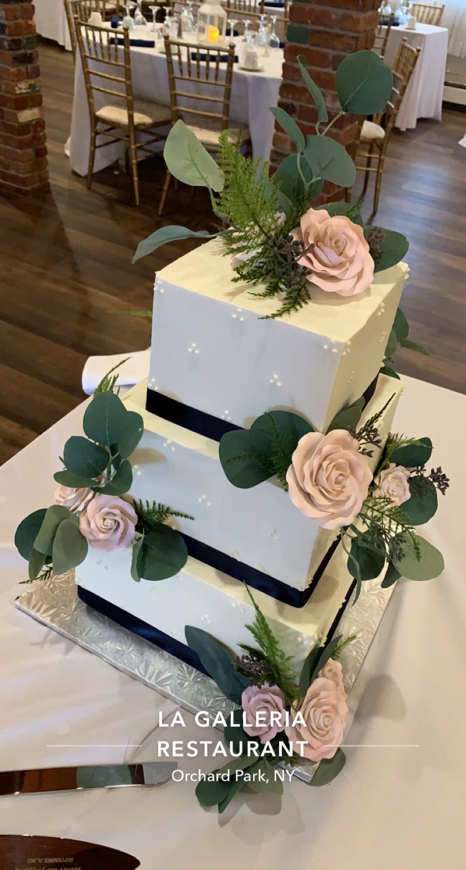 a wedding cake is sitting on top of a table decorated with flowers .