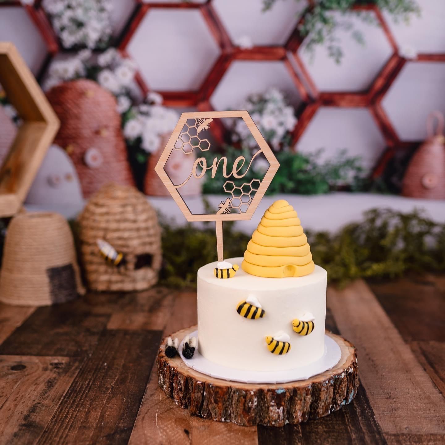 a cake with bees and a beehive on it is on a wooden table .