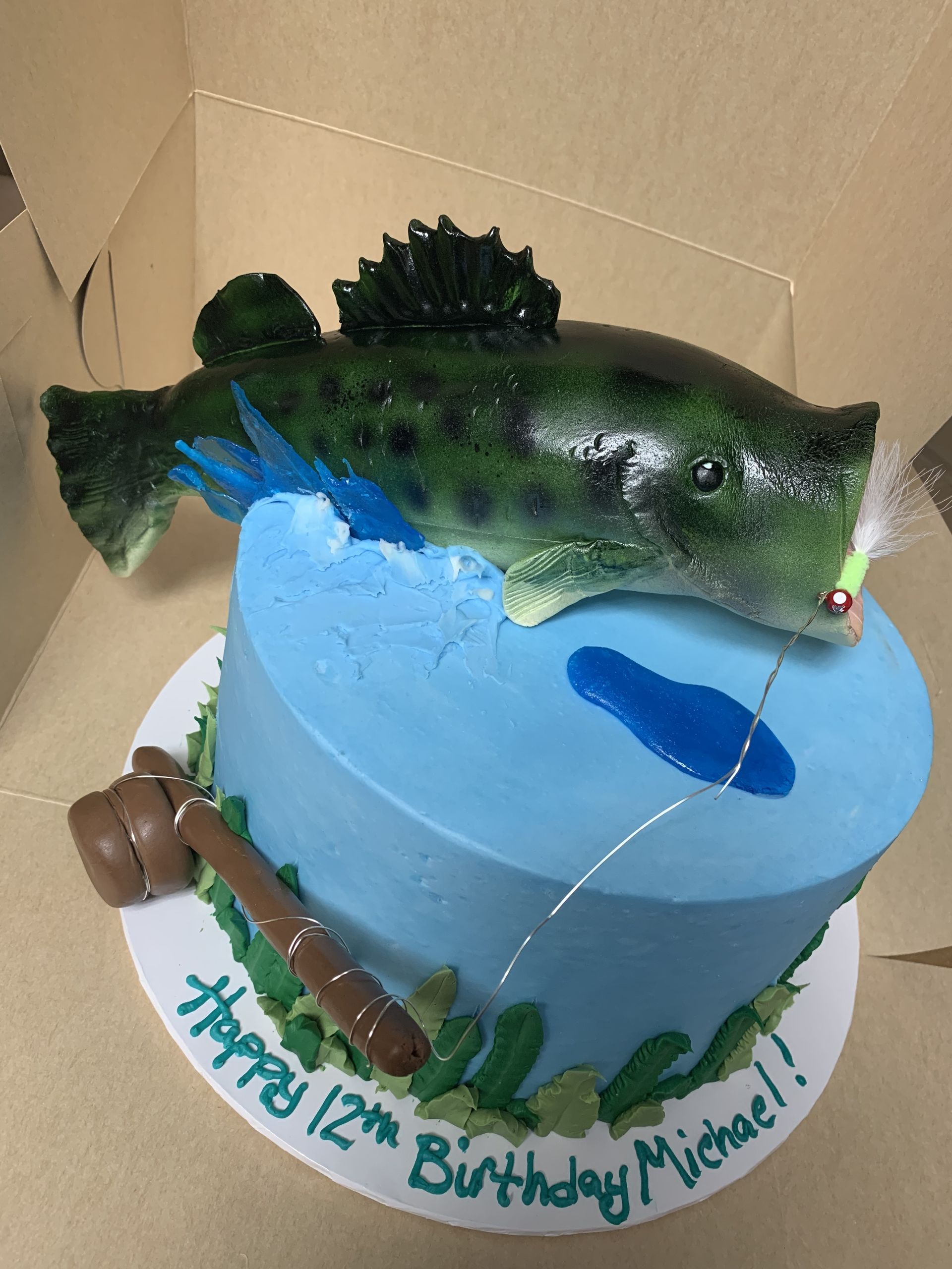 a birthday cake with a fish and a fishing rod on it