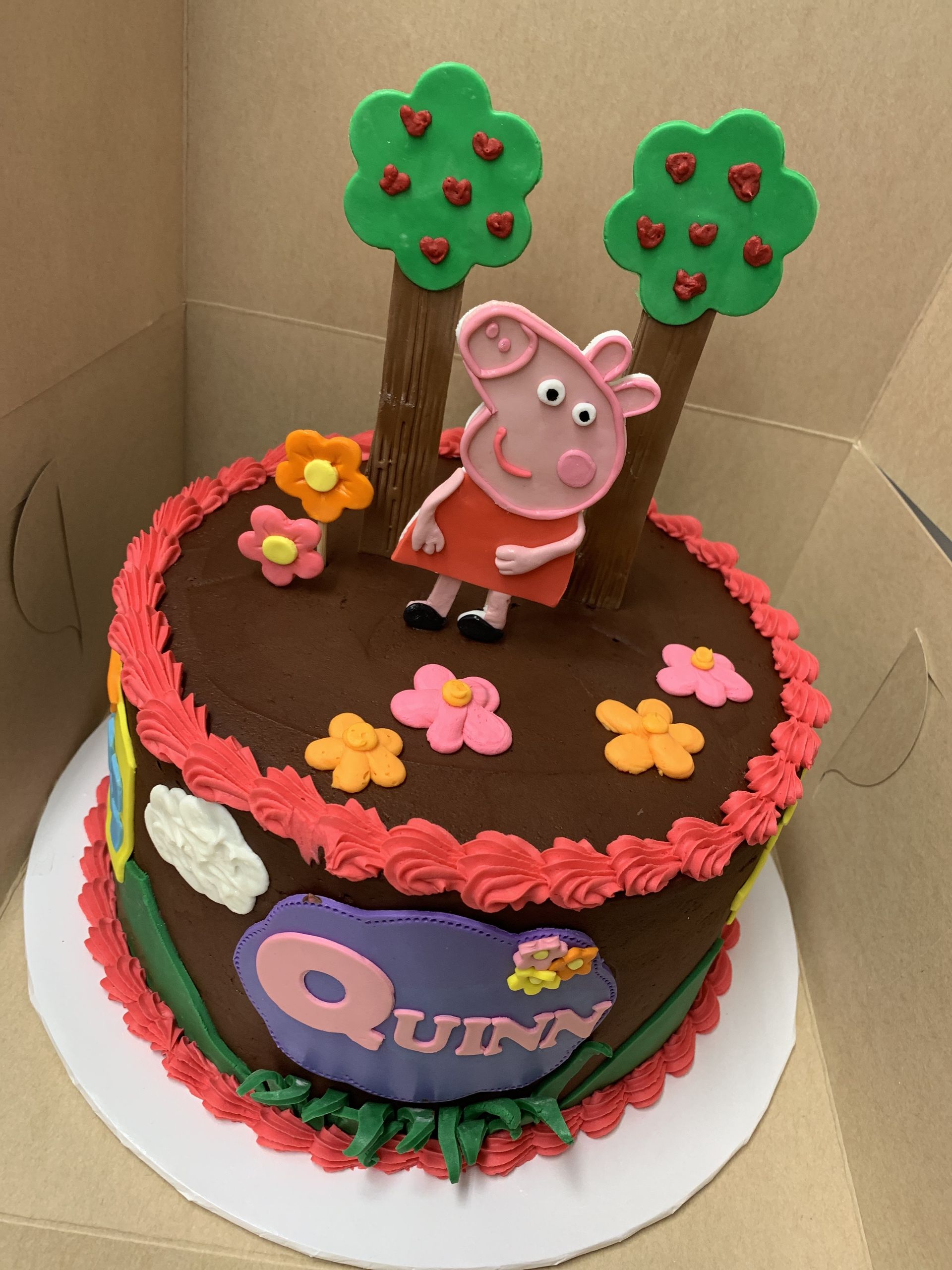 a birthday cake for quinn with peppa pig on top
