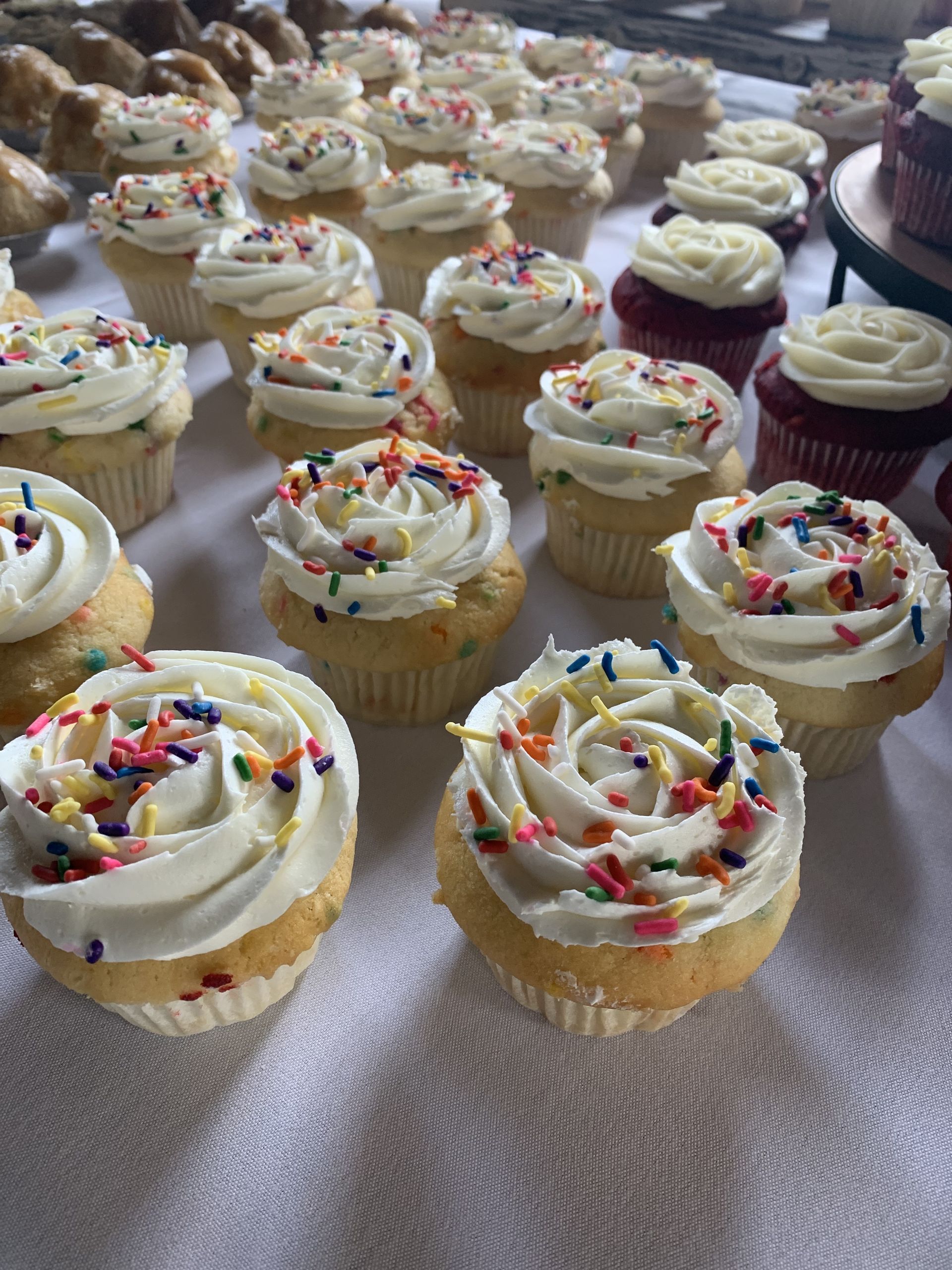 a bunch of cupcakes with frosting and sprinkles on a table .