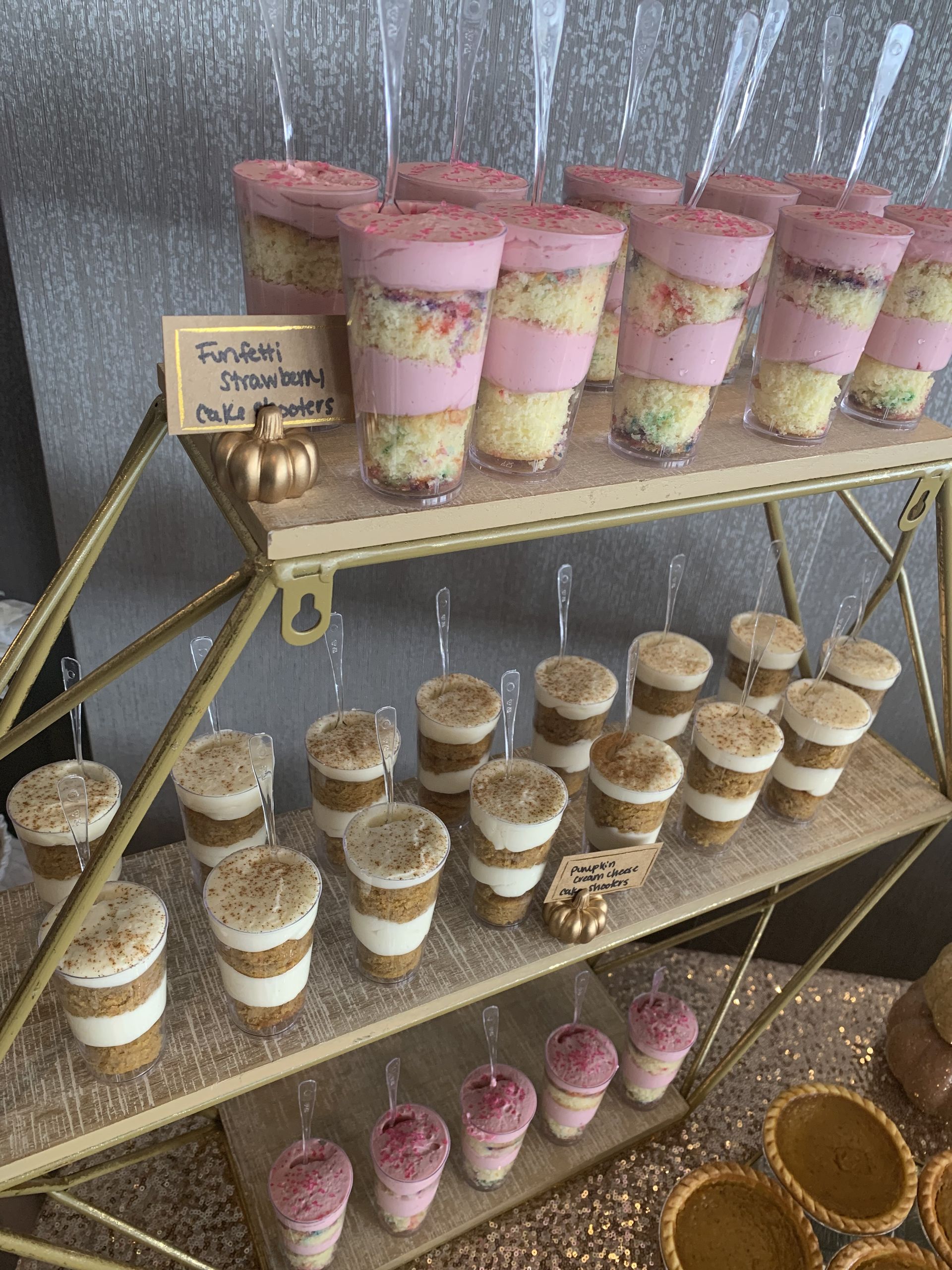 a display of desserts in shot glasses on a table .