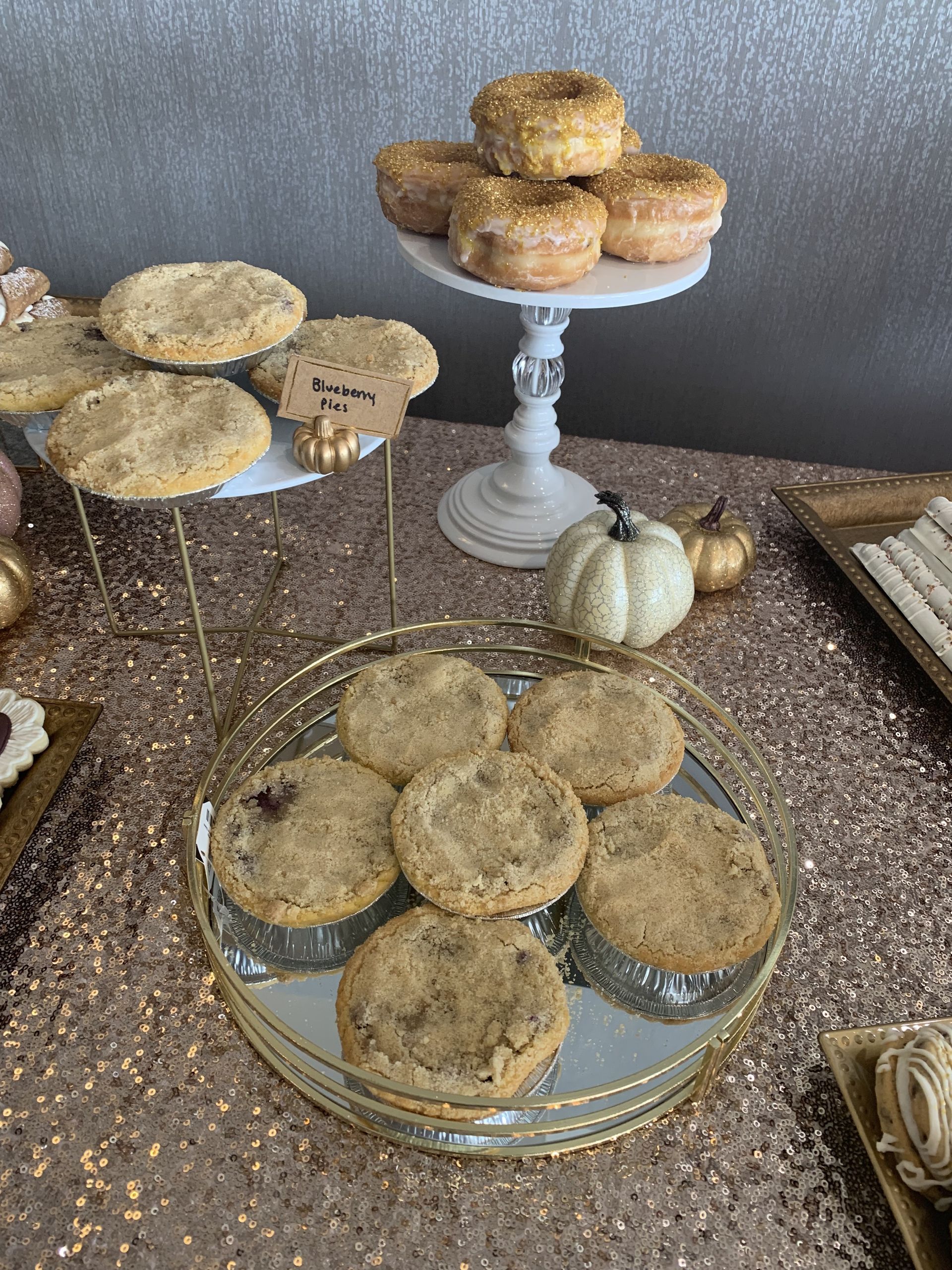 a table topped with a variety of desserts including cookies and donuts .