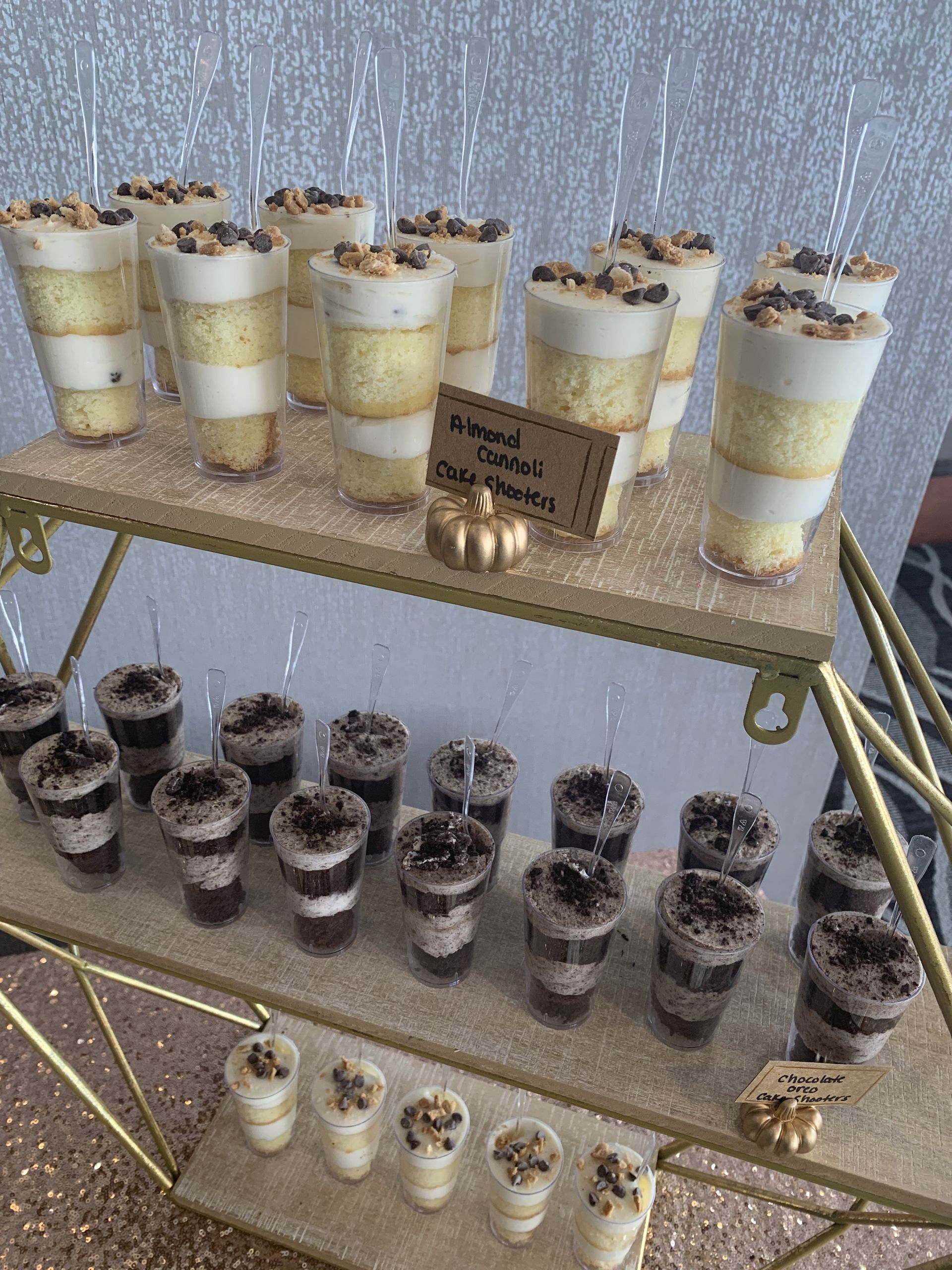 a display of desserts in shot glasses on a table .