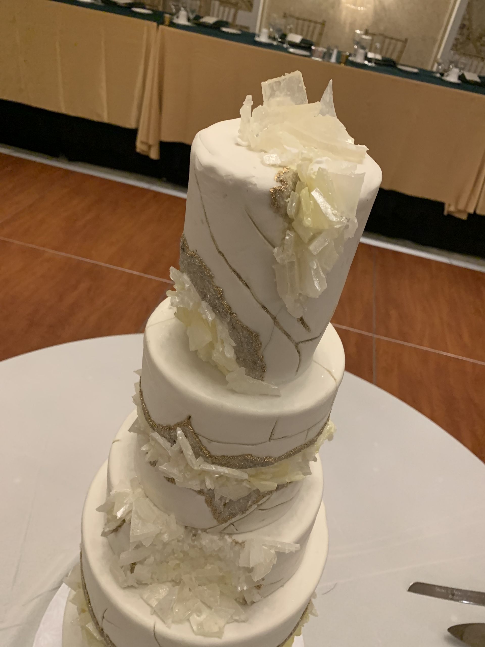 a three tiered white wedding cake is on a white table