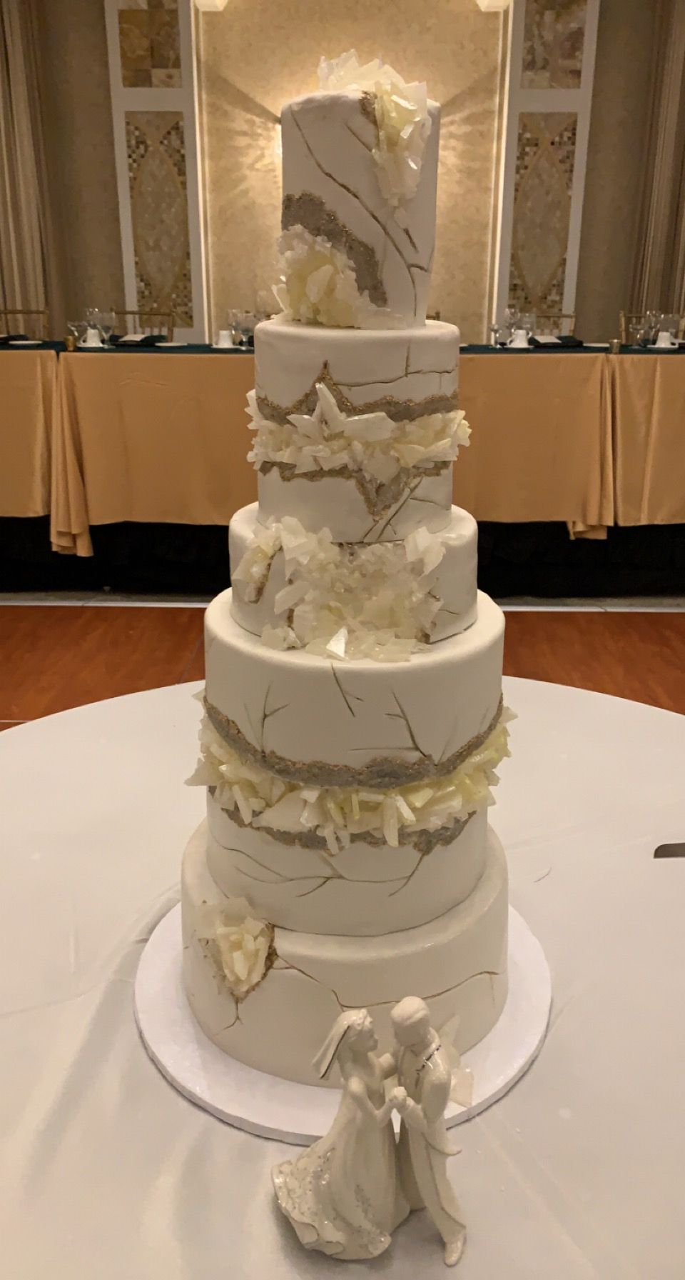 a white wedding cake is sitting on top of a white table .