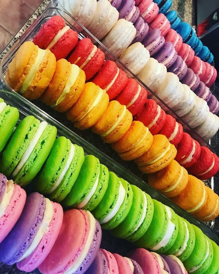 many different colored macarons are lined up in rows