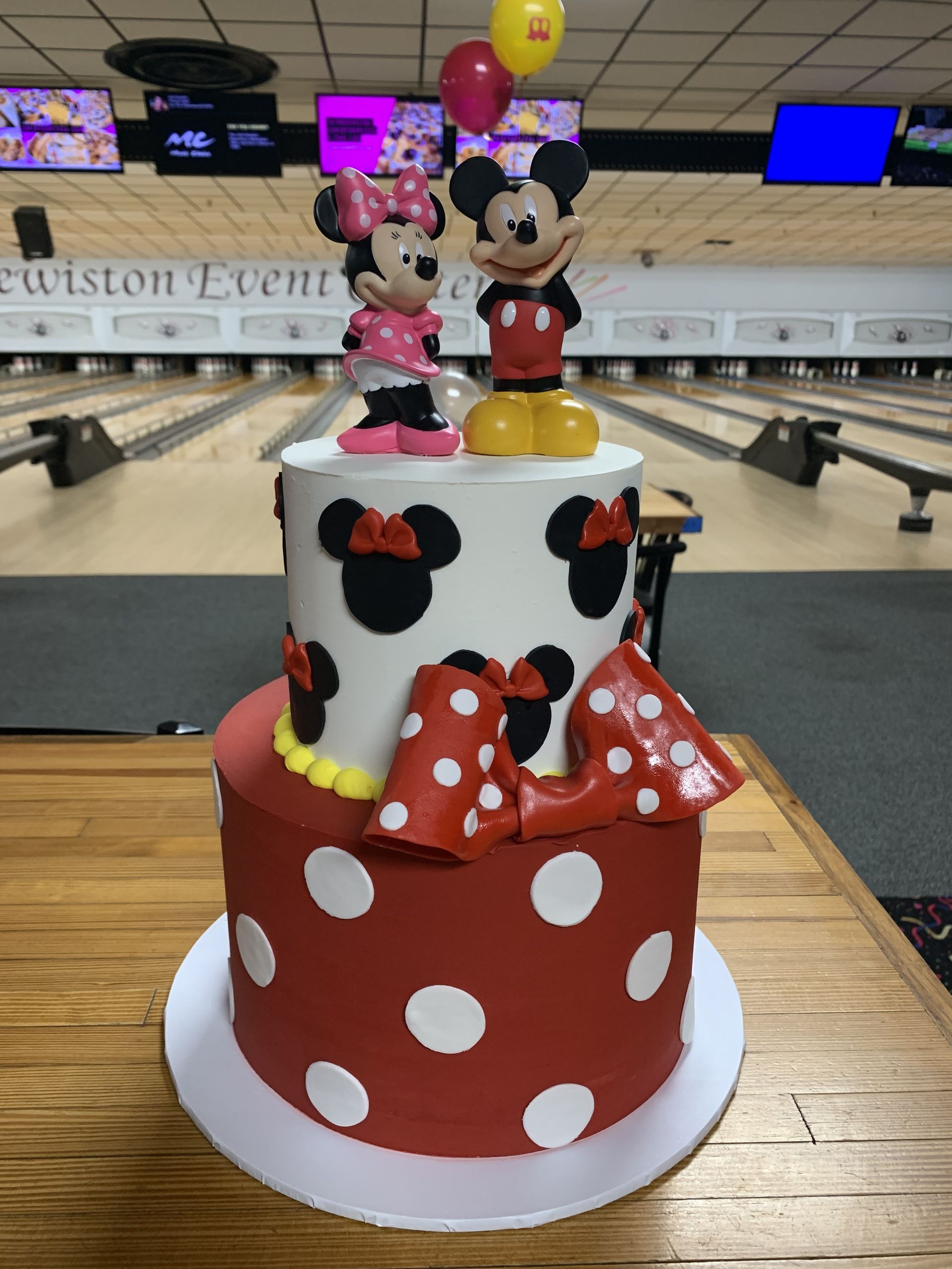 a cake with mickey mouse and minnie mouse on top of it