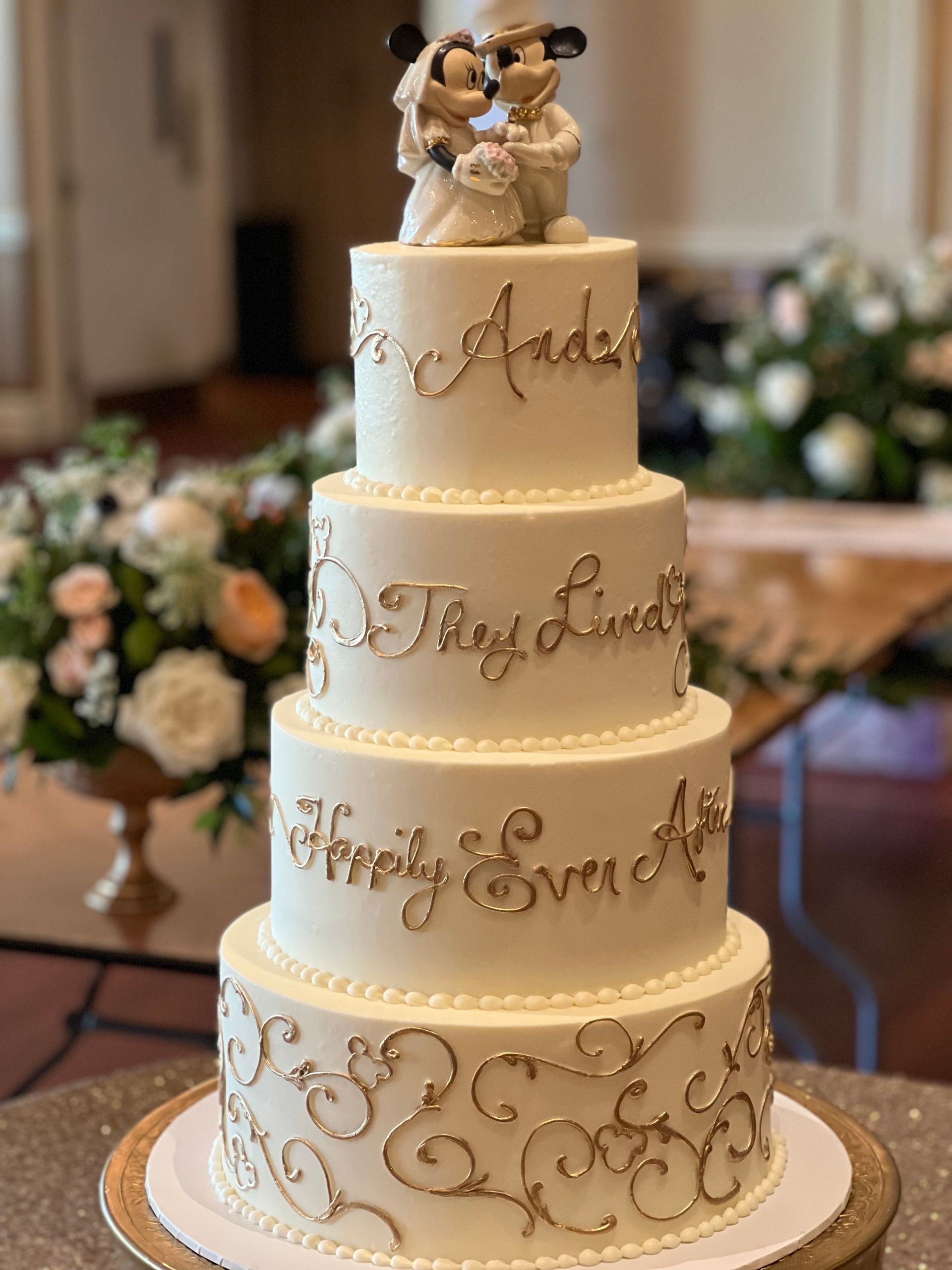 a wedding cake with mickey mouse and minnie mouse on top of it .