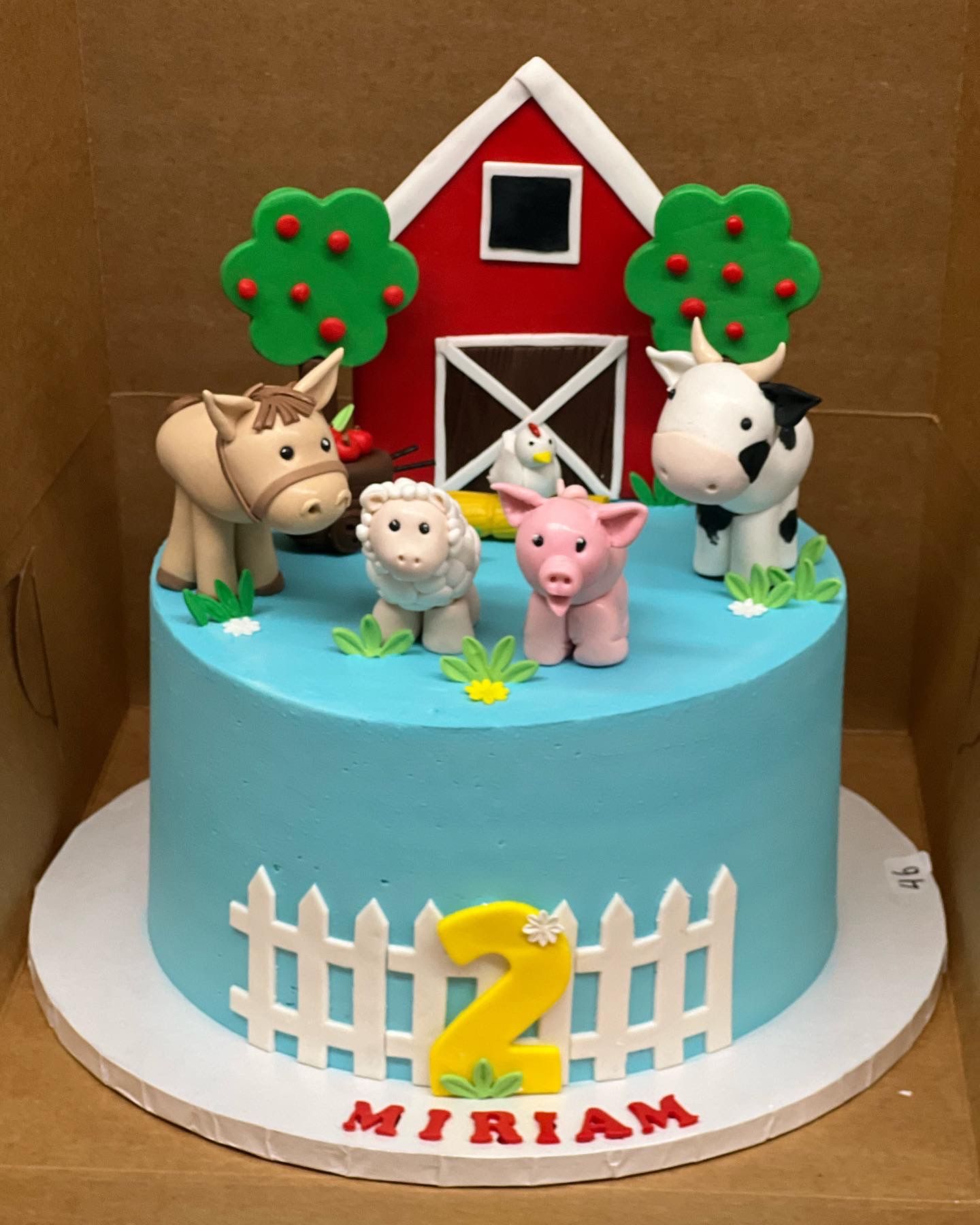 a blue cake with farm animals and the number 2 on it