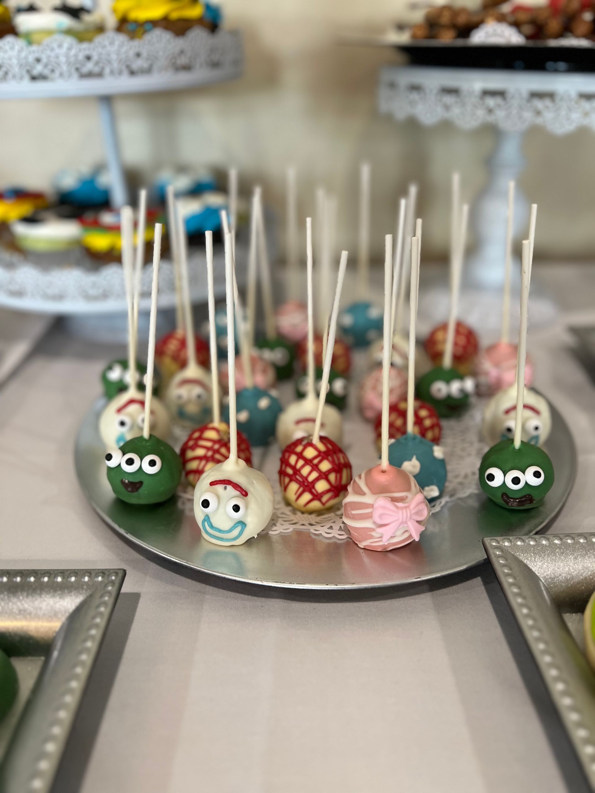 a plate of cake pops with faces on them on a table .