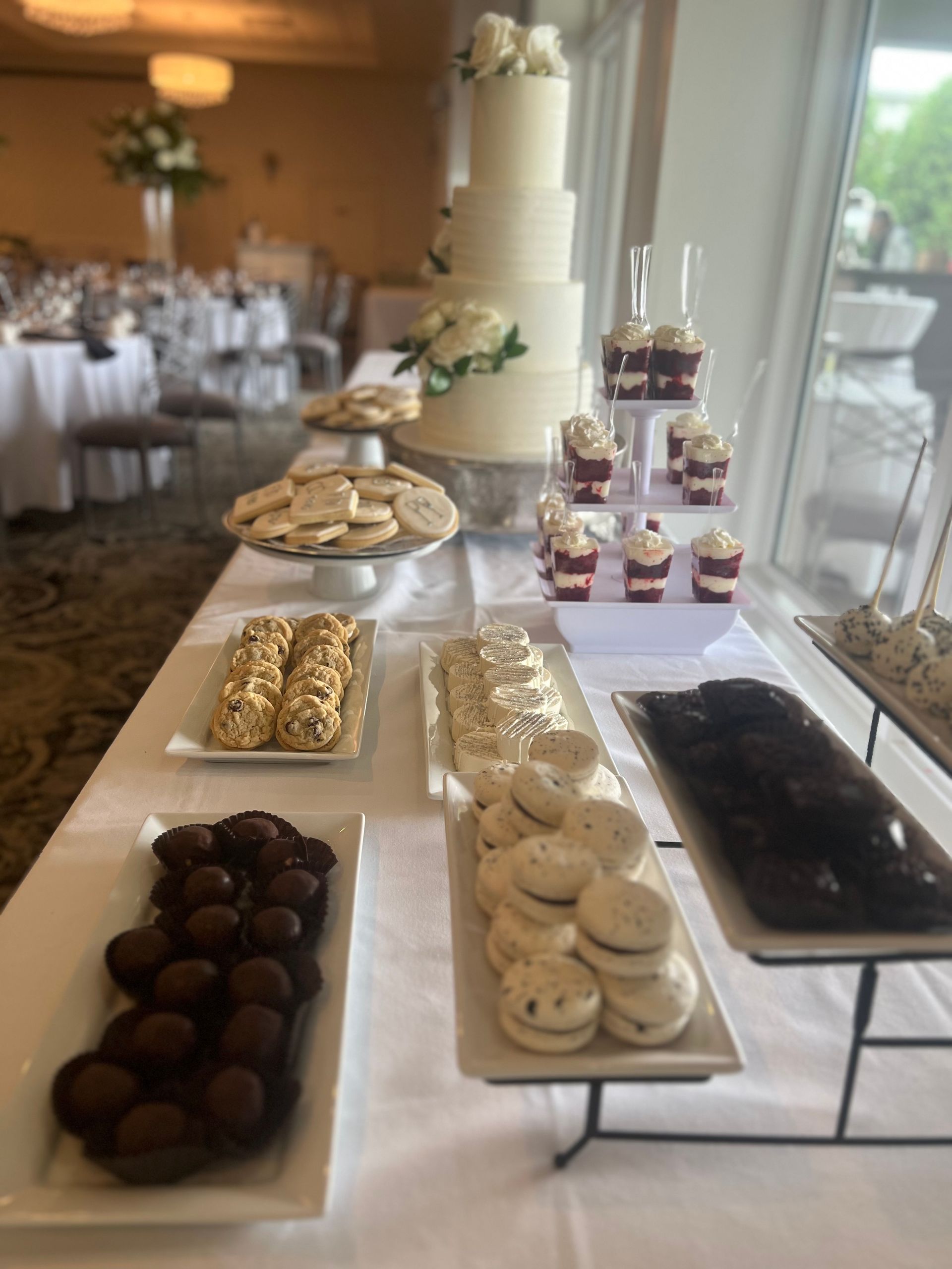 a table with a cake , cookies , cupcakes and other desserts on it .
