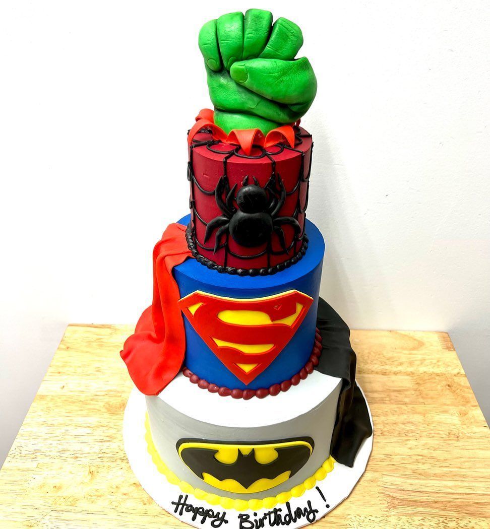 a birthday cake with spiderman superman and batman on it