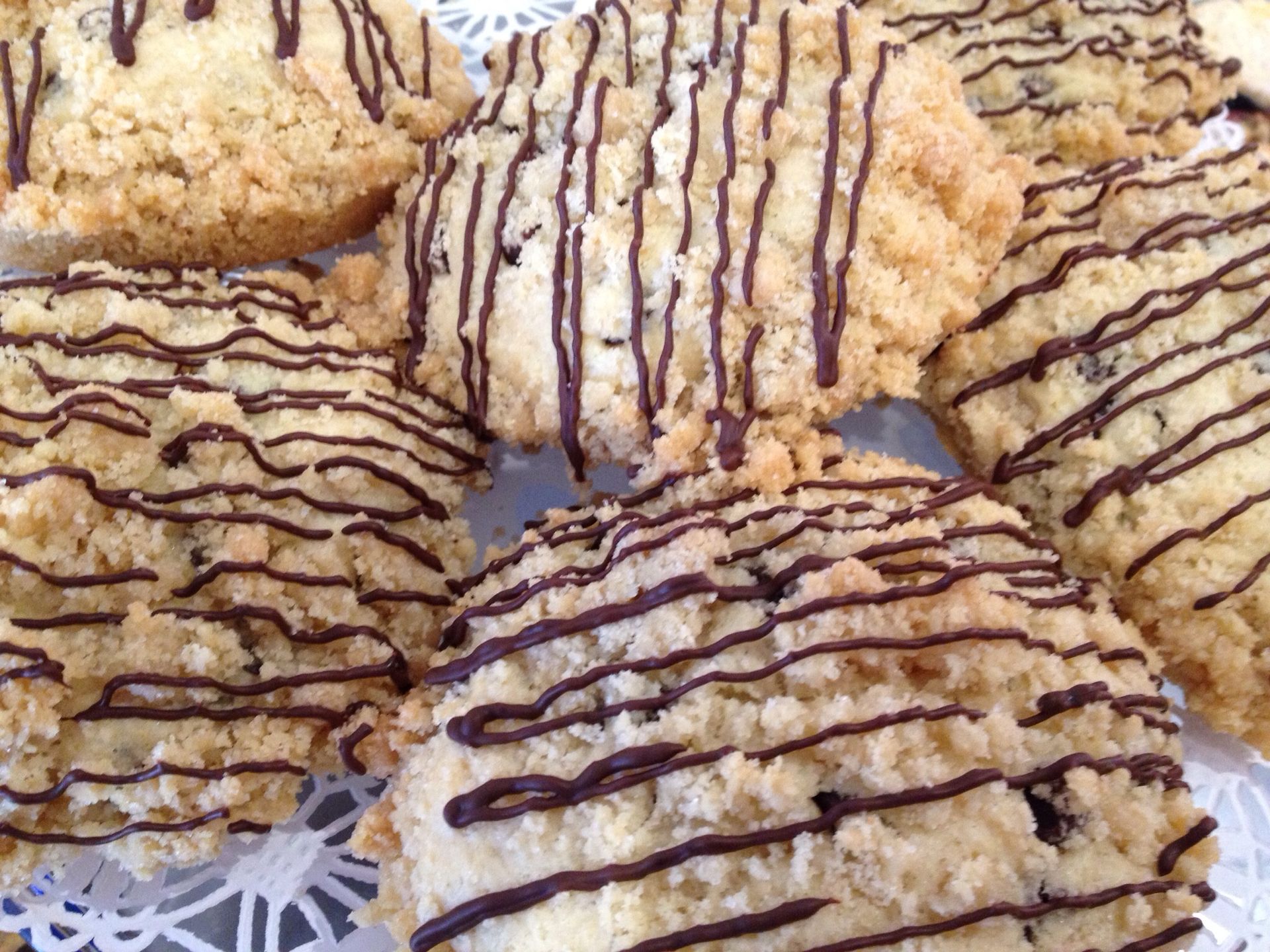 a plate of cookies with chocolate drizzle on them