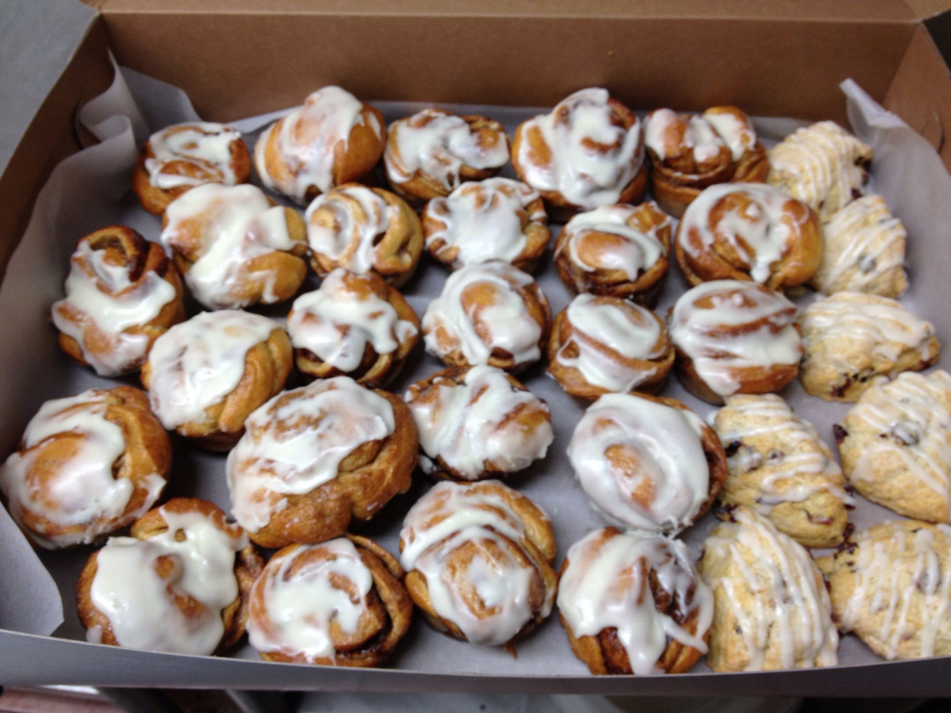 a box filled with a variety of cinnamon rolls and cookies
