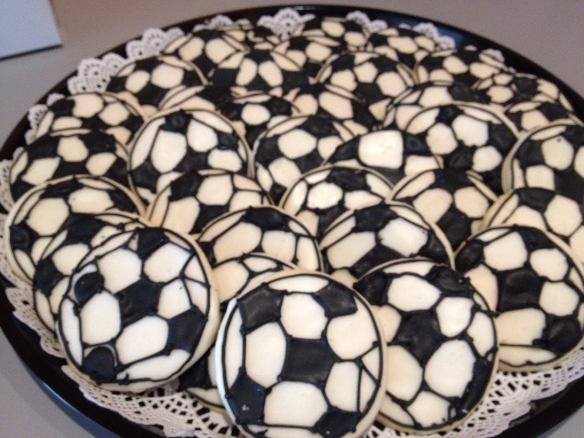 a black plate topped with black and white soccer balls