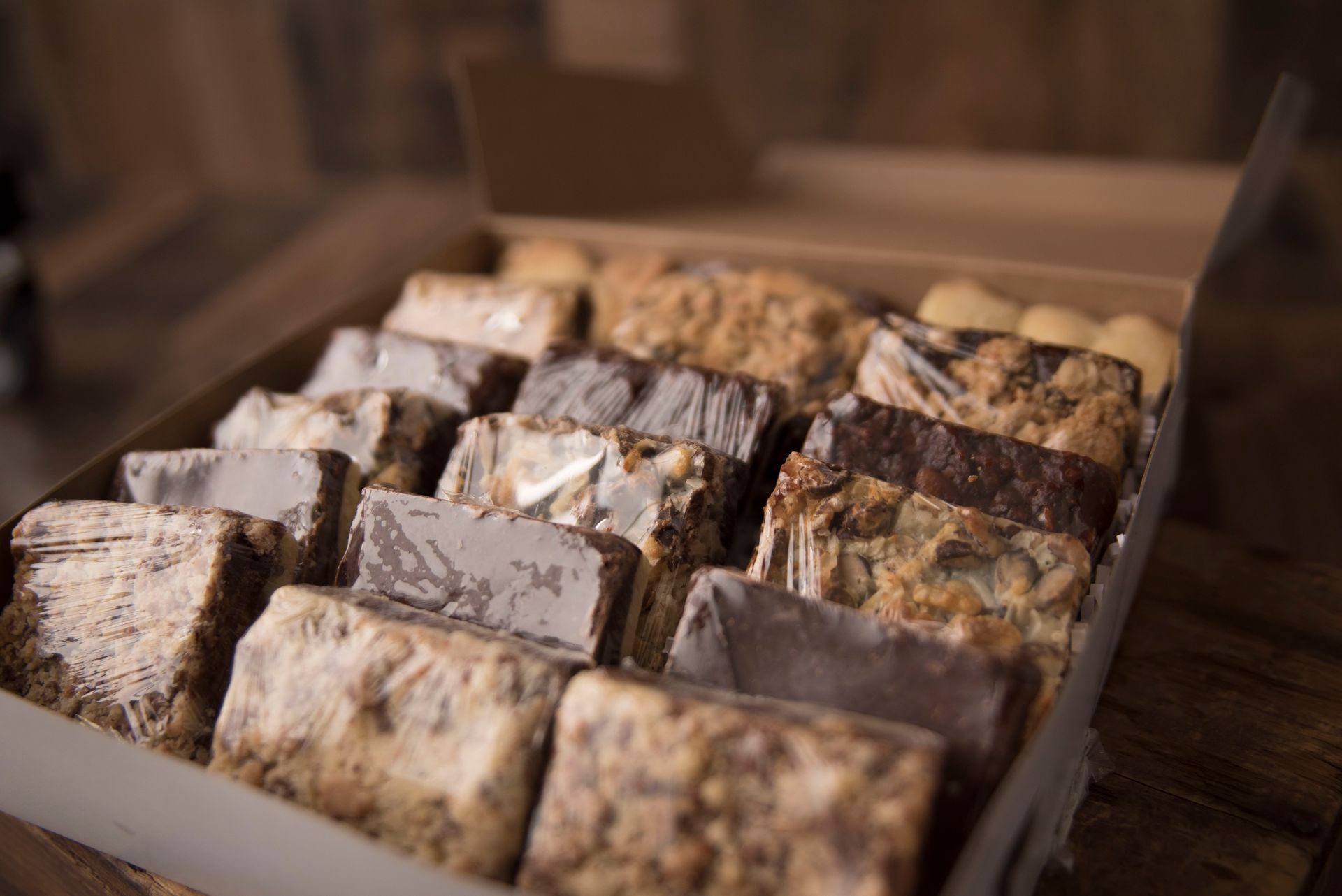 a box filled with a variety of desserts on a wooden table .