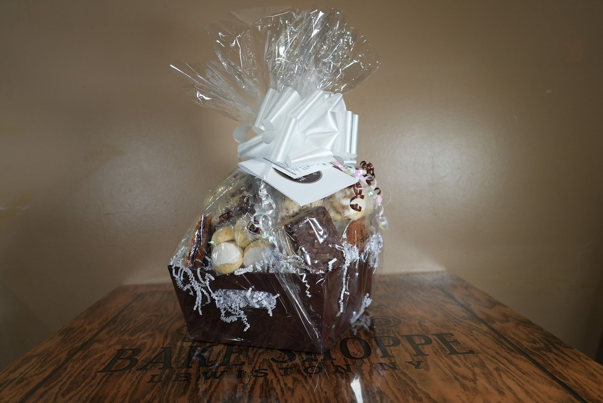 a gift basket wrapped in plastic is sitting on a wooden table .